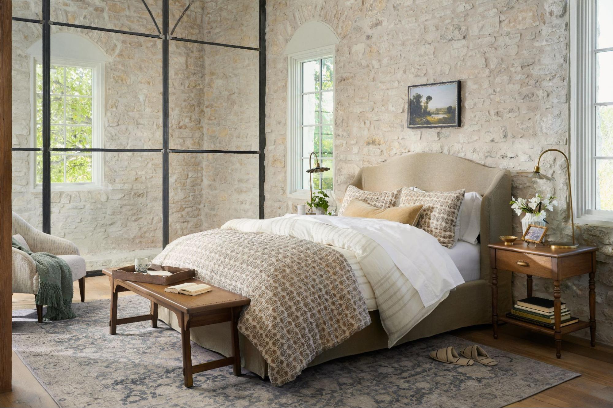 A bed is layered in Magnoliass's Flora Block Print Quilt with matching shams and a neutral sheet set.