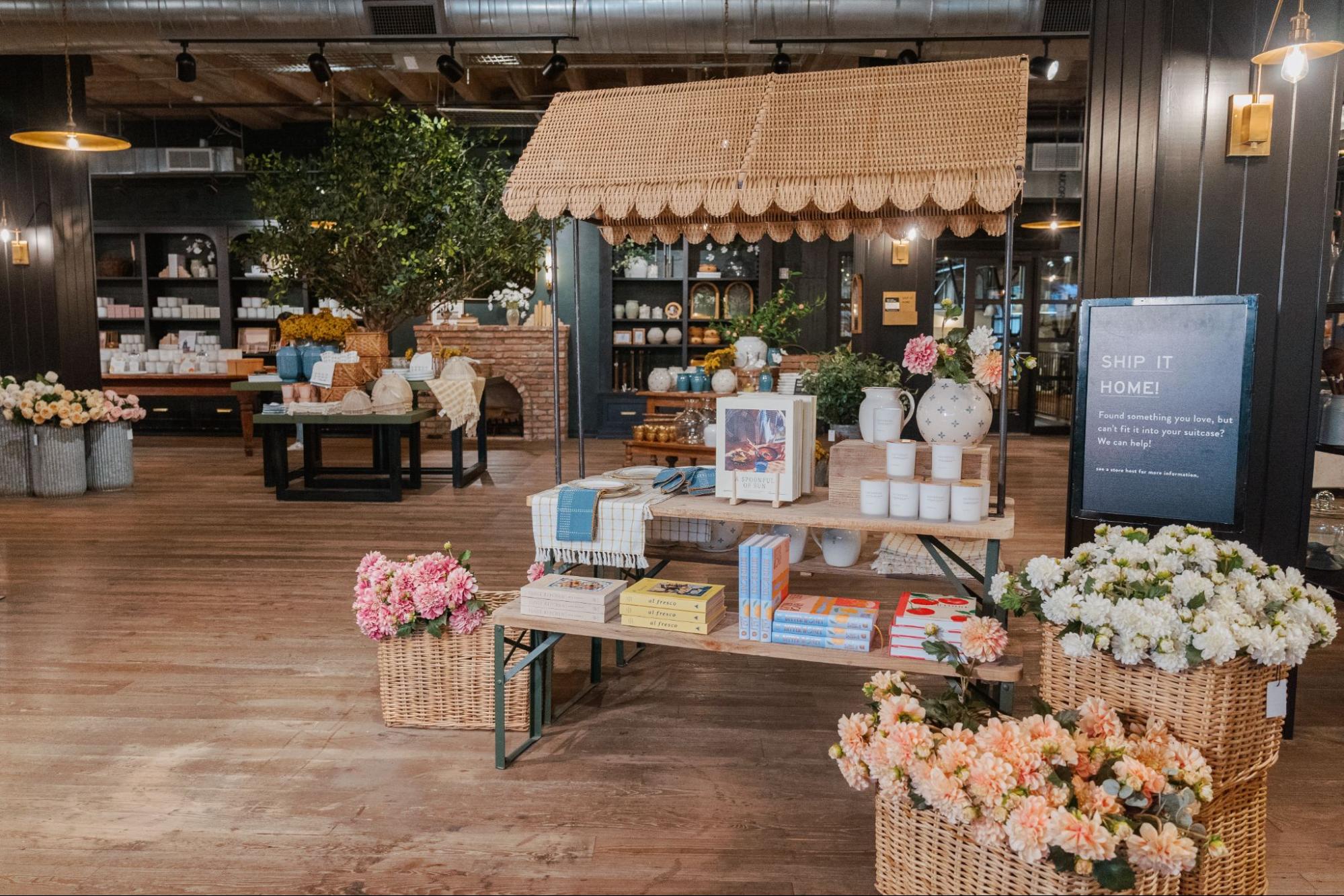 Magnoliass Market is dressed with summer displays, like a scalloped canopy, faux florals, candles, cookbooks, and more.