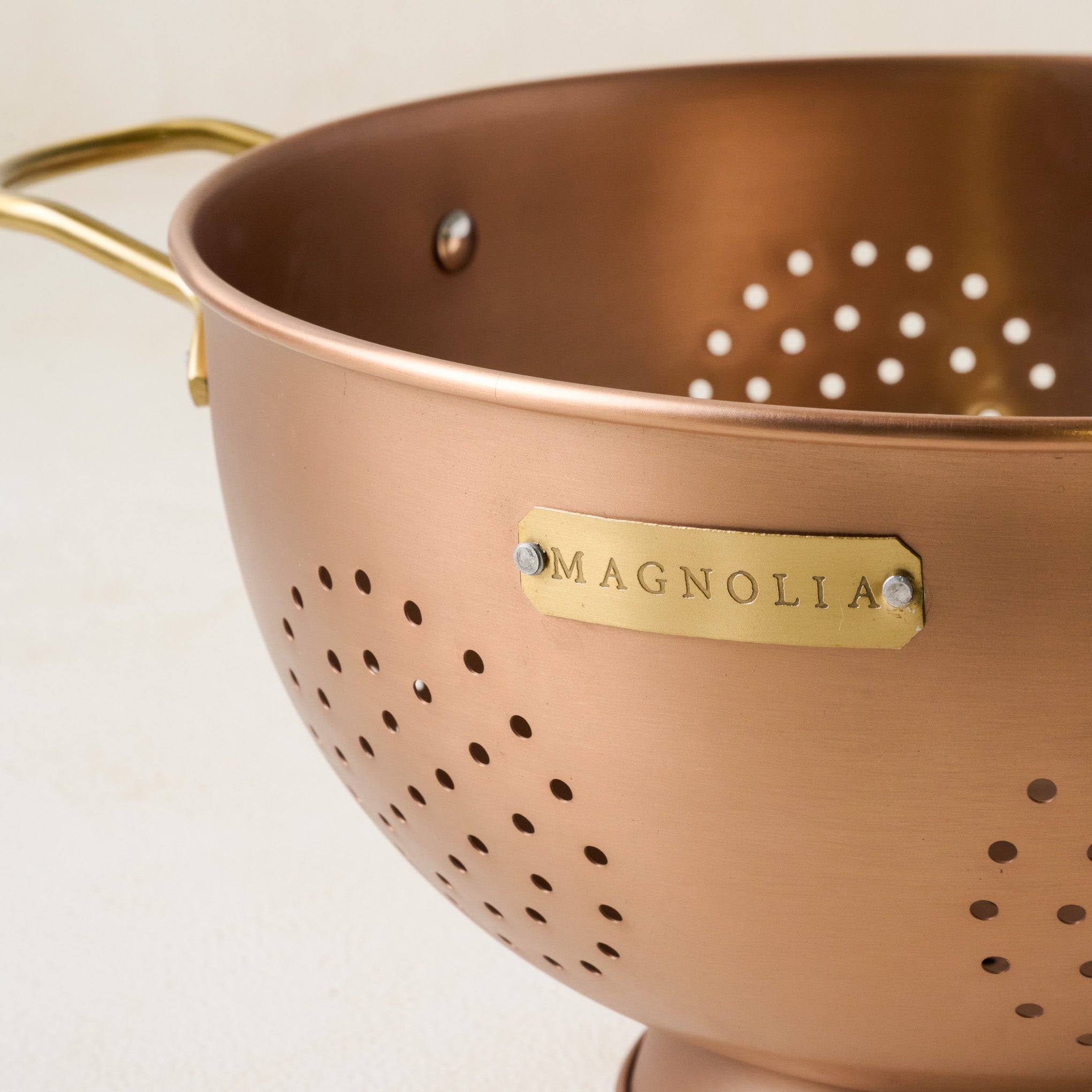 Copper and Brass Colander close up of Magnoliass logo
