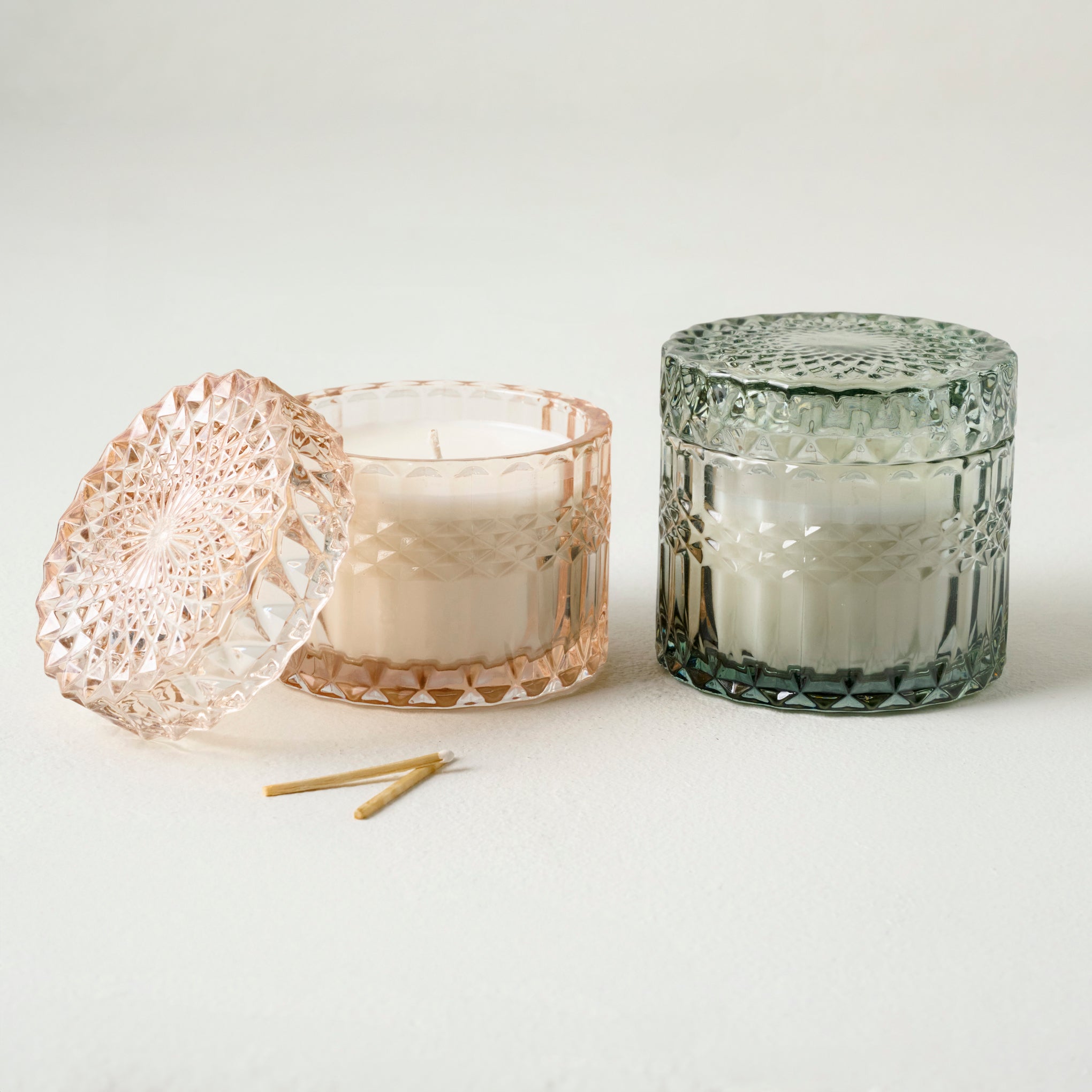 Magnoliass Shoreline Glass Candle shown with another glass candle