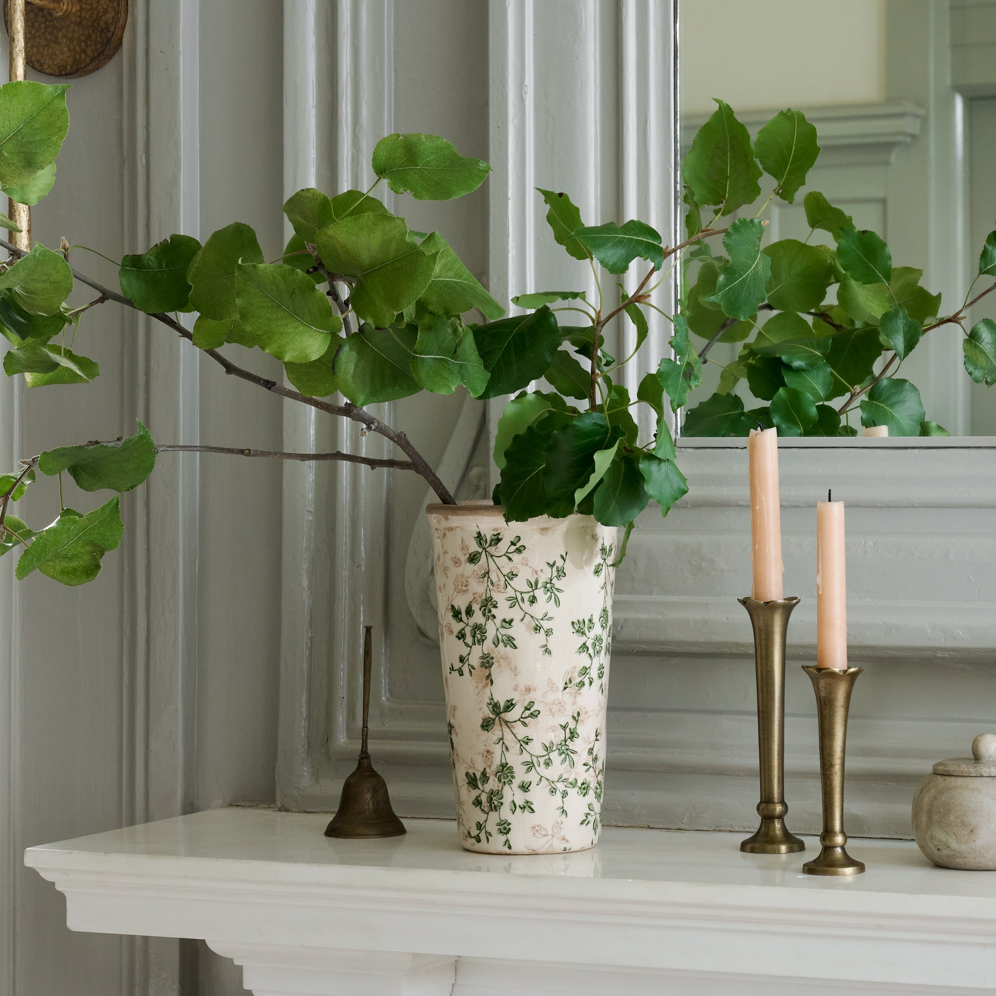 flannery scalloped brass bud vase with tapers sitting on mantel