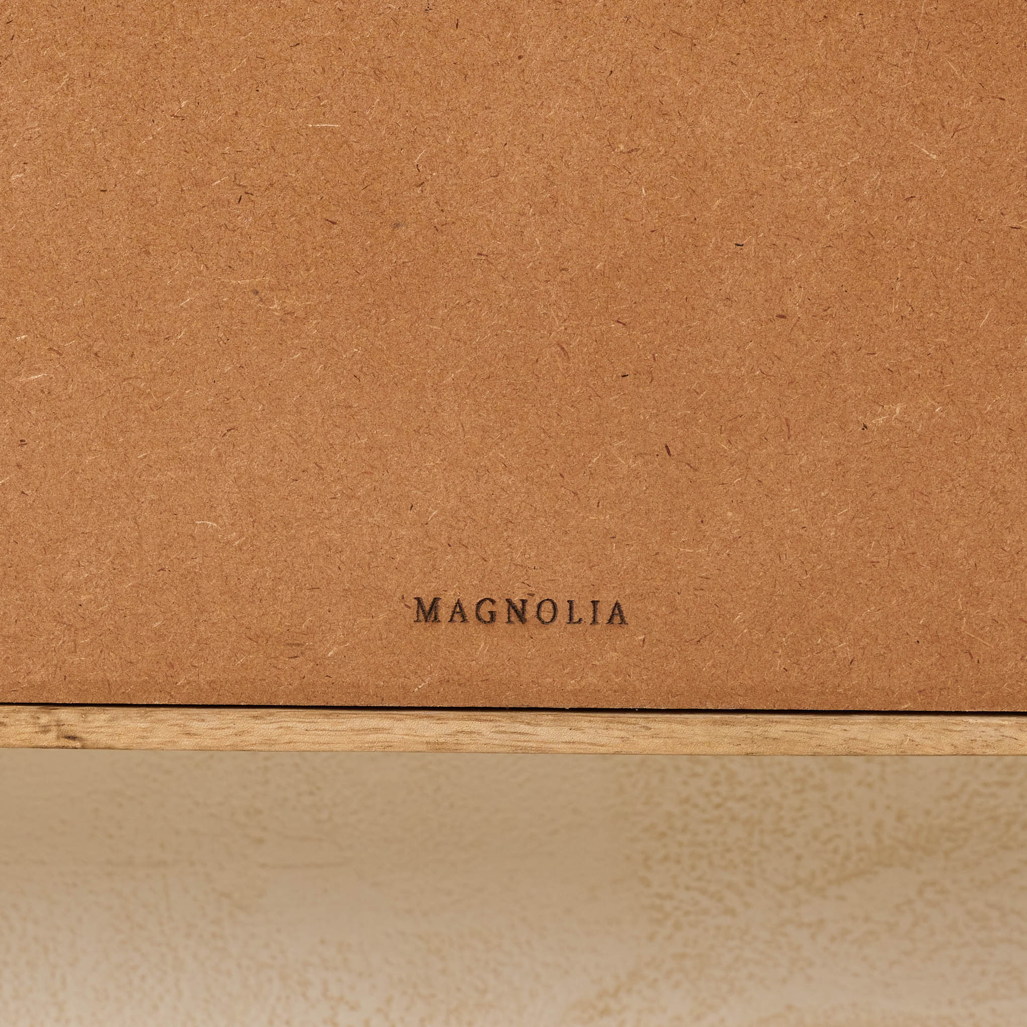 Belmar Arched Woven Wall Shelf close up of Magnoliass logo on the back of shelf