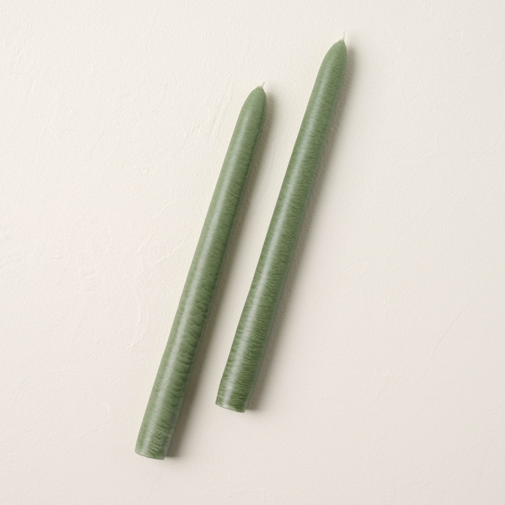 two colonial green taper candles