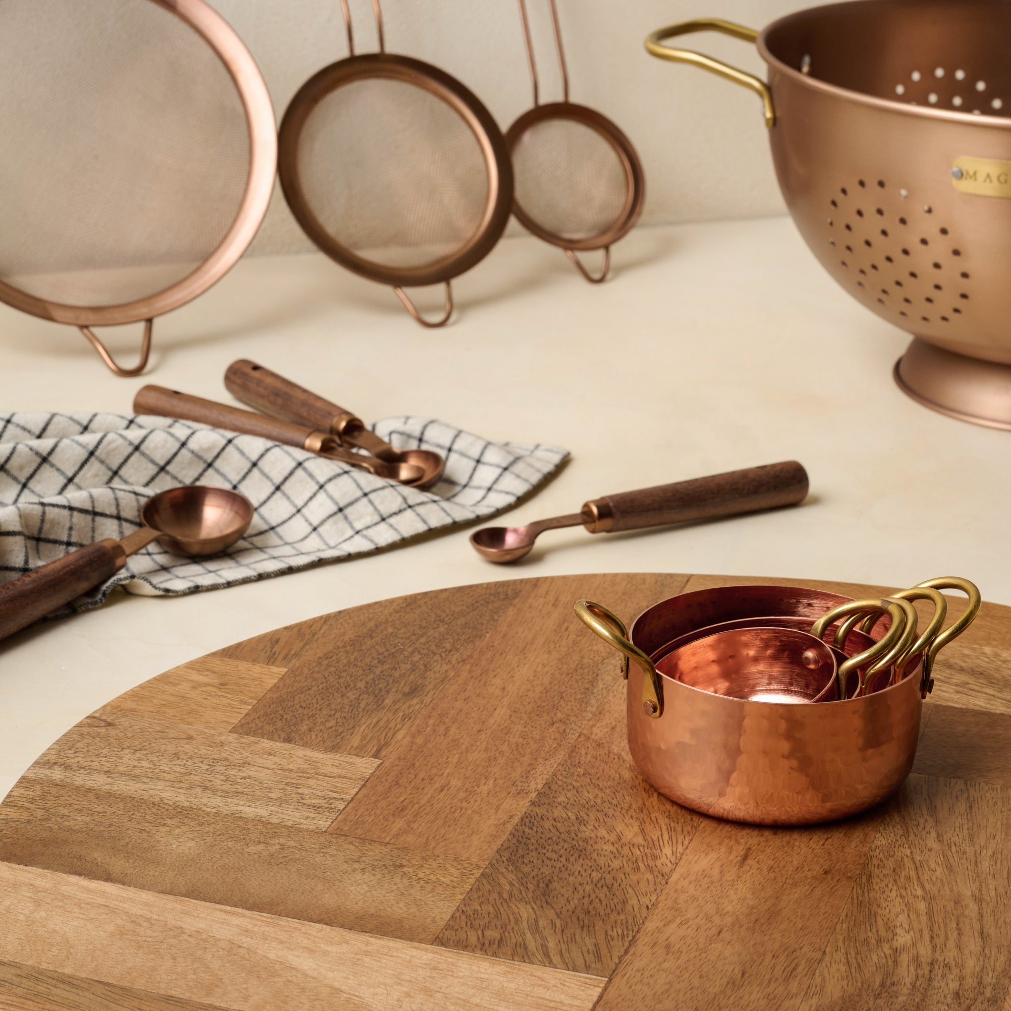 Copper and Brass Colander next to other kitchen supplies