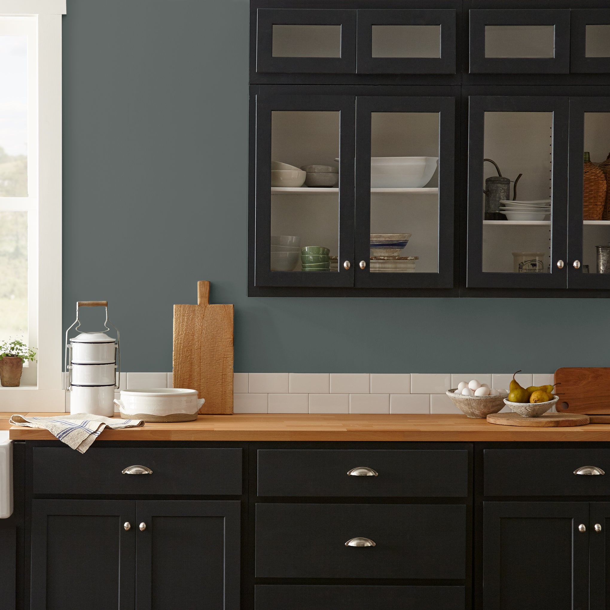 Ridge Rock paint featured in kitchen walls with dark blue cabinets and wood countertops