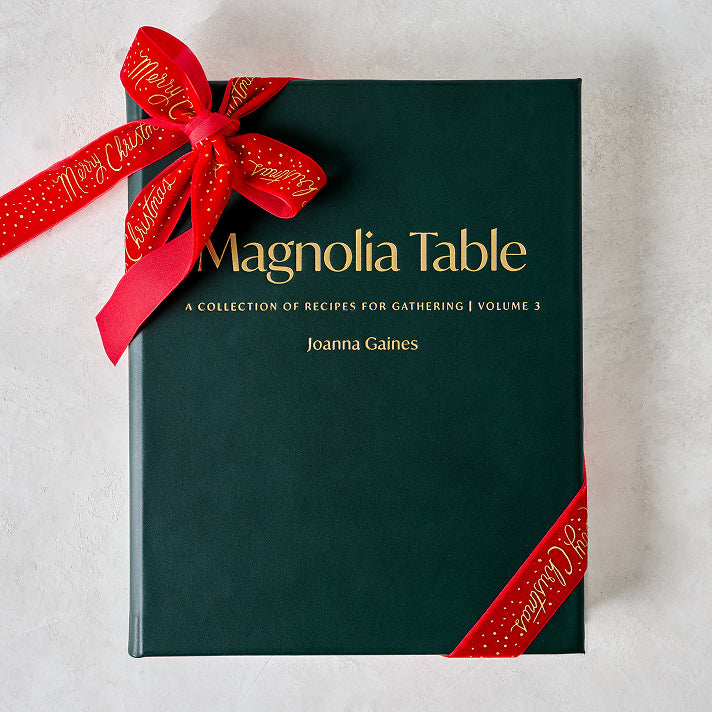 Book titled 'Magnolia Table' with a red ribbon on a light background