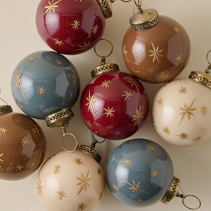 Decorative Christmas ornaments with gold star patterns on a neutral background