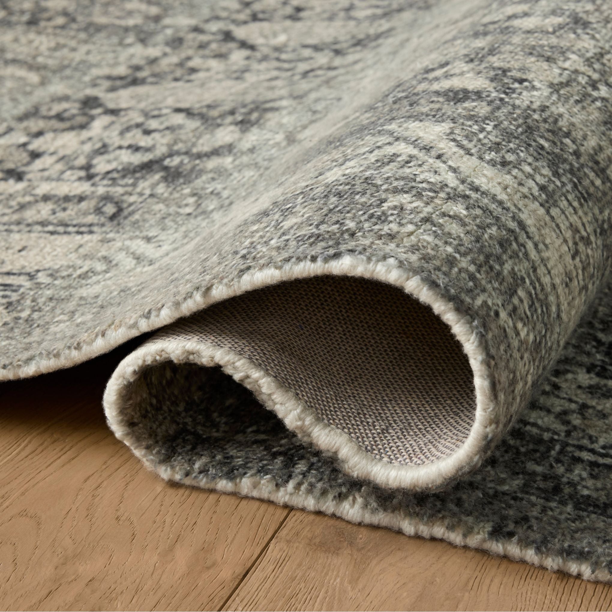 Wimberly Granite Cream Rug shown rolled/folded
