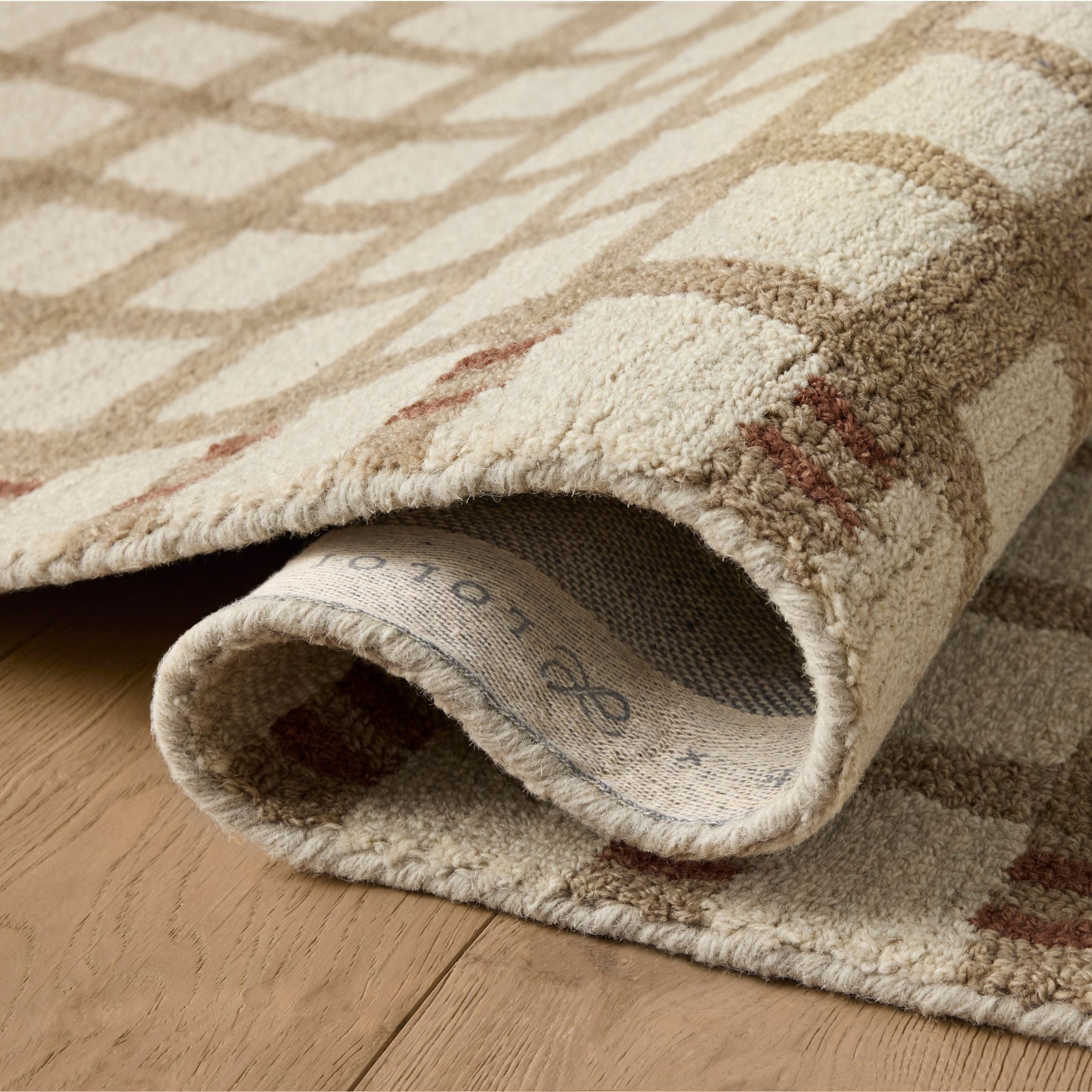 Waylon Natural Rust Rug shown rolled/folded