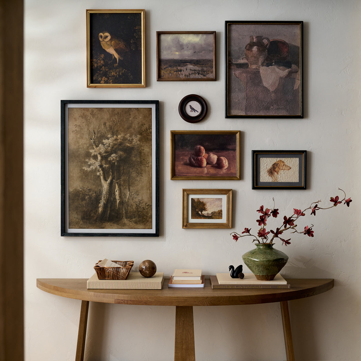 Wall with framed artworks and a wooden console table with decorative items.  Shop Wall Decor.