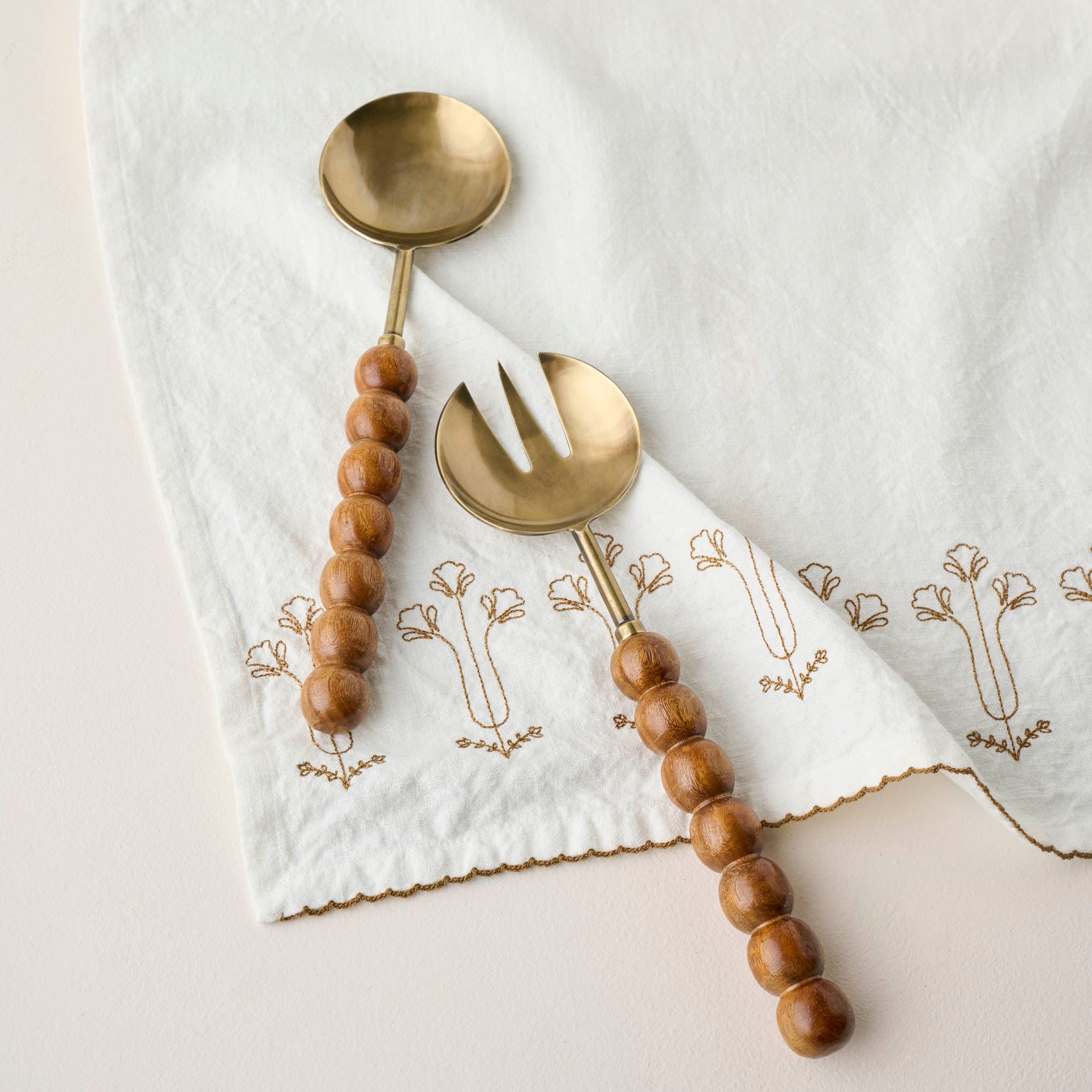 Antique Brass and Beaded Wood Serving Set shown on napkin