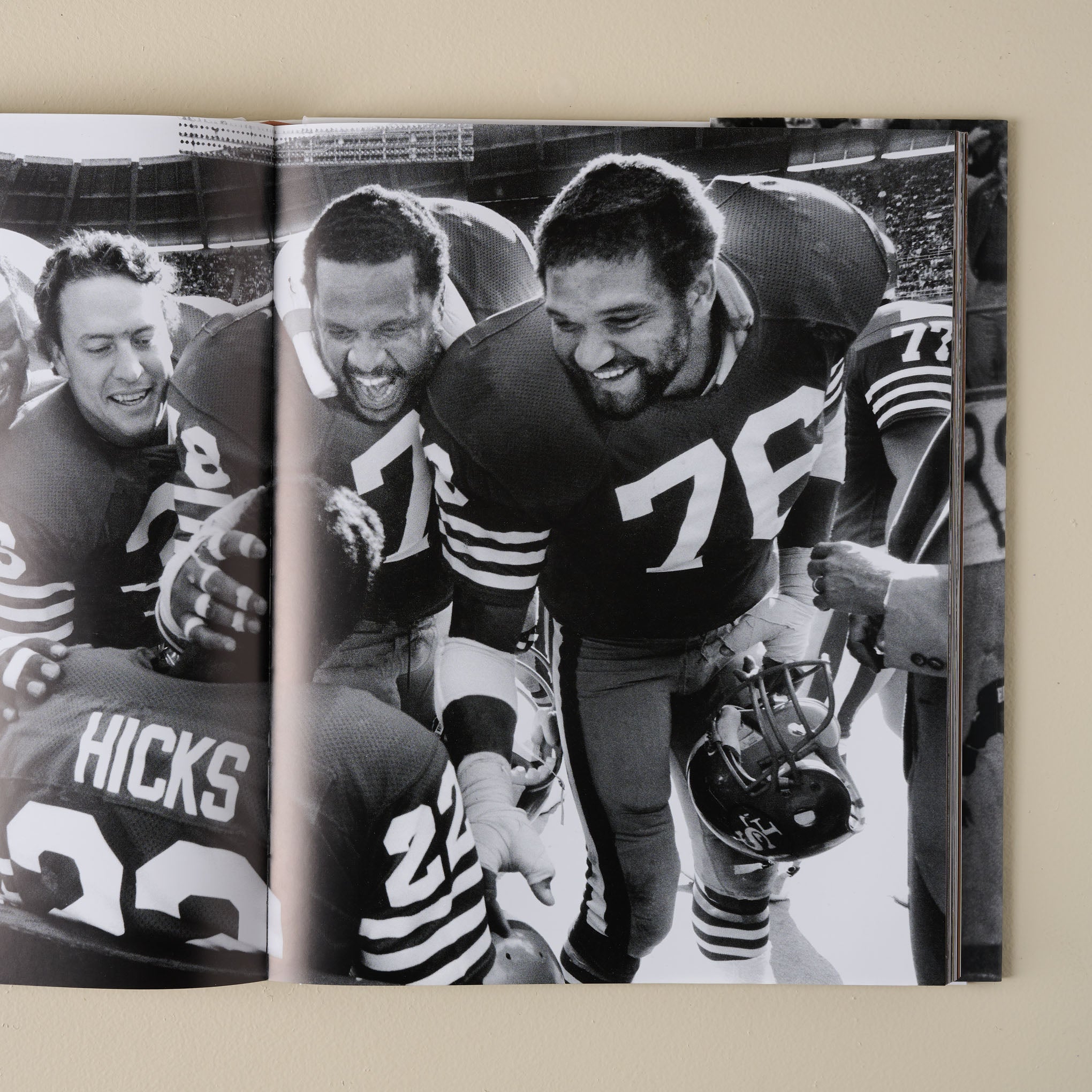 Field of Play: 60 Years of NFL Photography open to a page with players congratulating a player sitting on the bench