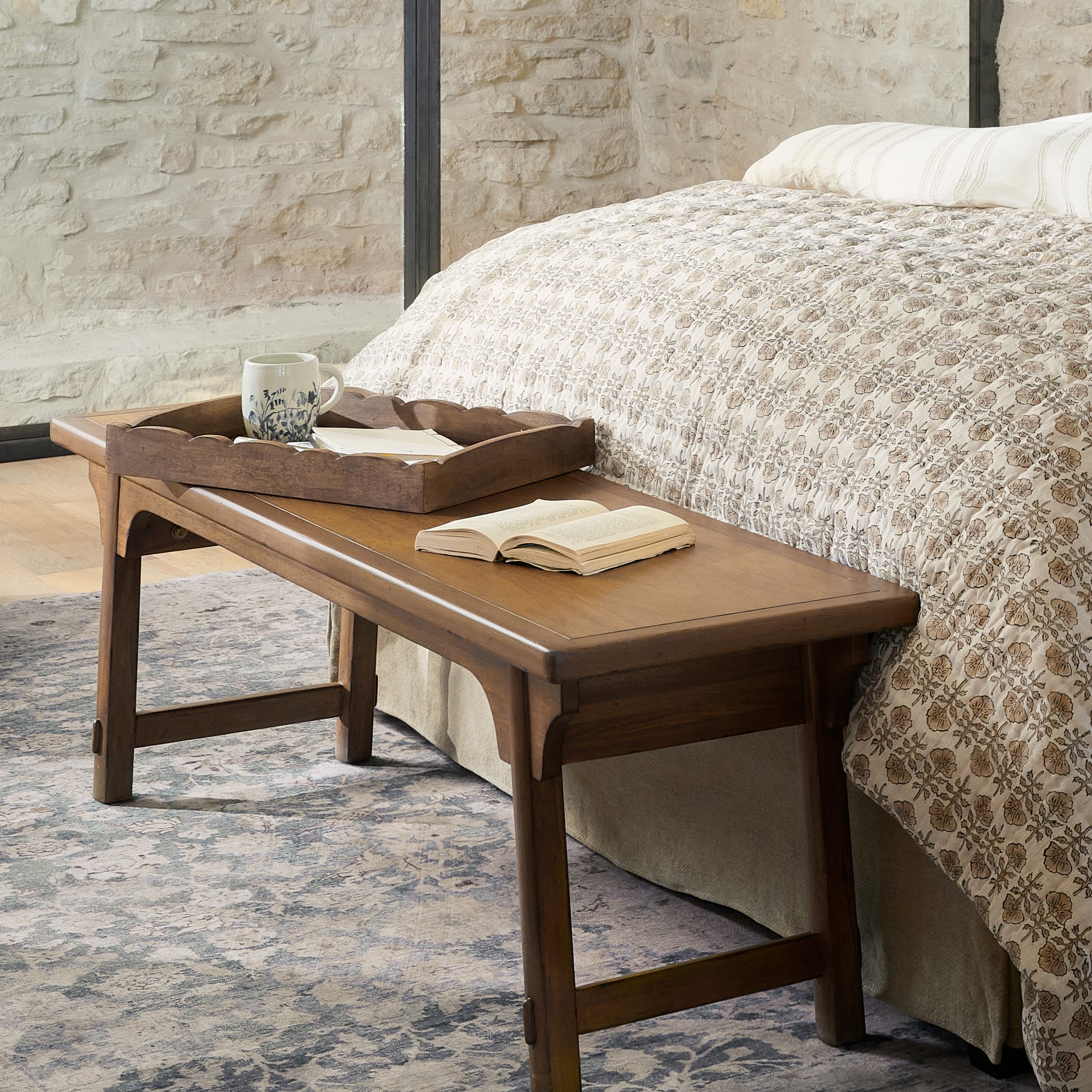 antiqued scallop wood tray on wood bench in front of bed