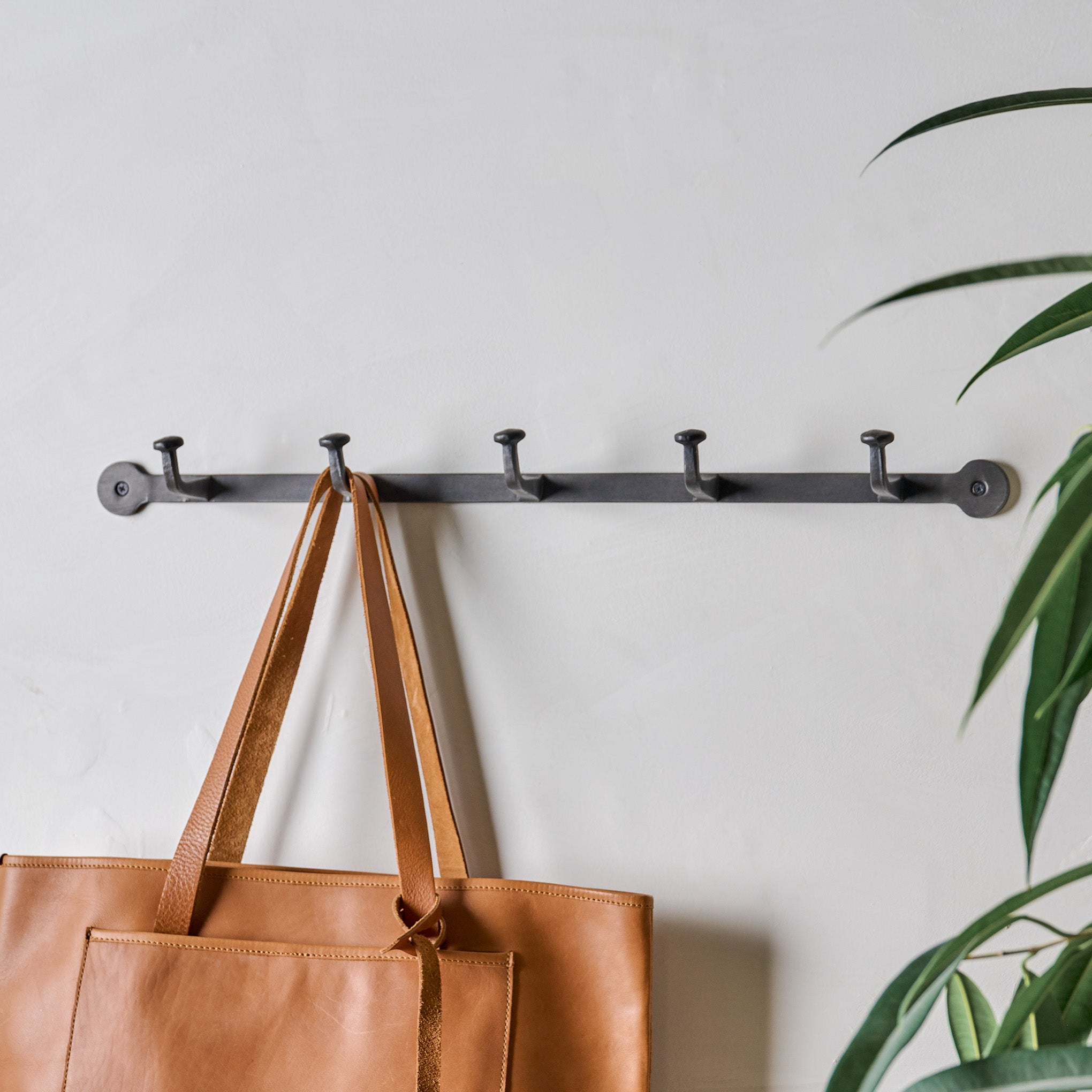 Large Hammered Aged Iron Wall Hooks shown with purse hanging