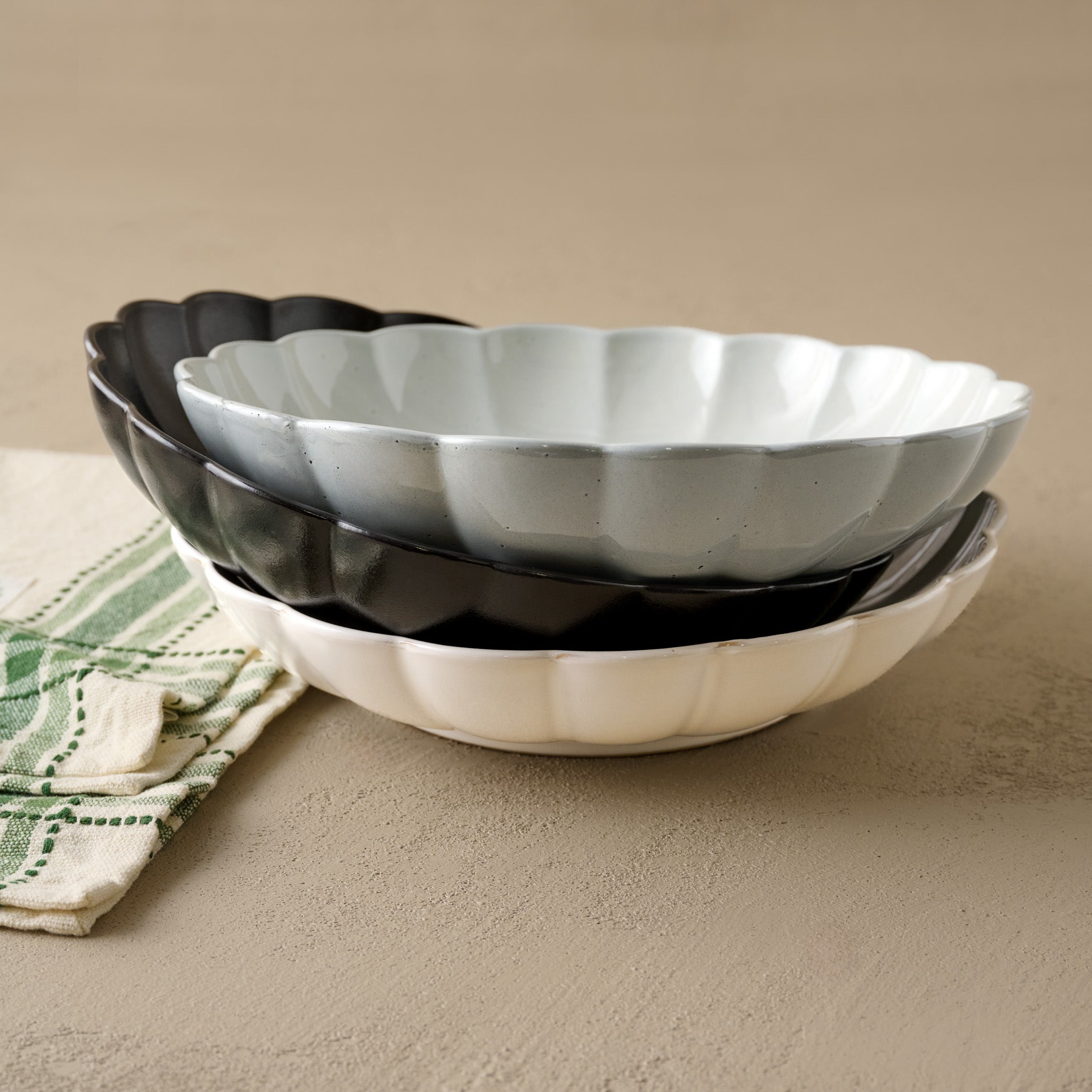 Oversized Black Scalloped Serving Bowl shown with cream and grey oversized scalloped serving bowls
