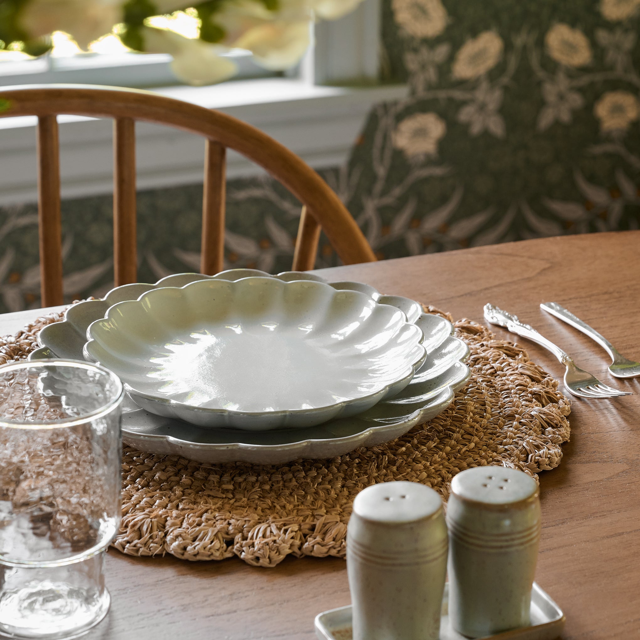 Grey Scalloped Plates stacked on top of a placemat
