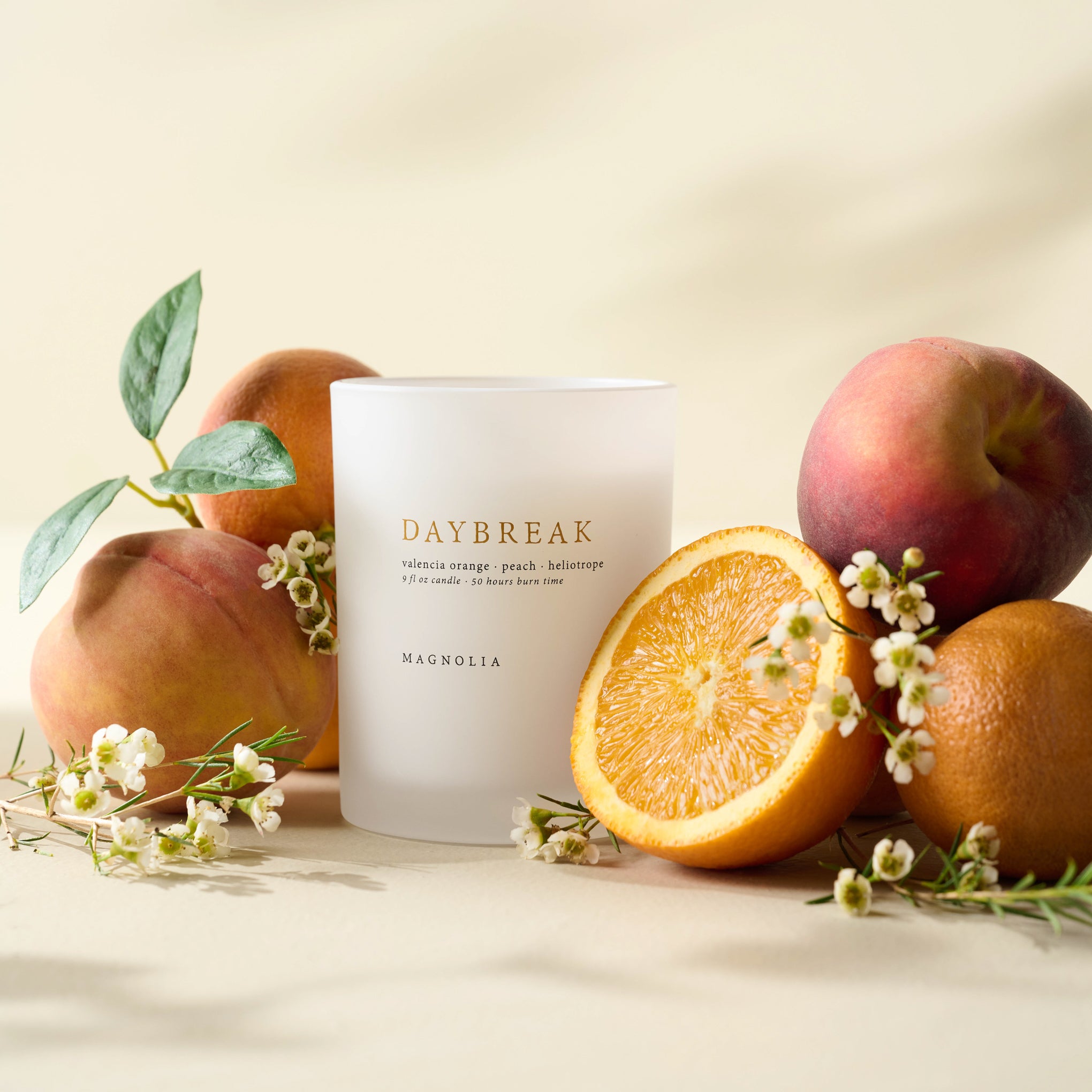 Magnoliass Daybreak Candle with peaches, oranges and flowers
