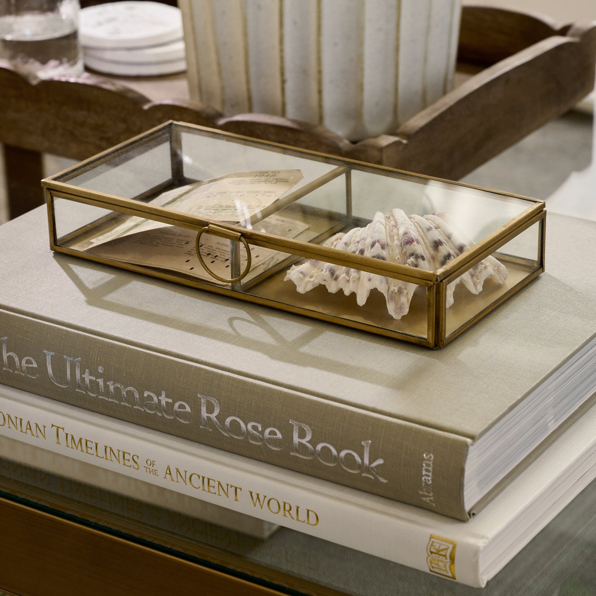 Antique Brass Keepsake Box on top of stacked books with a seashell inside