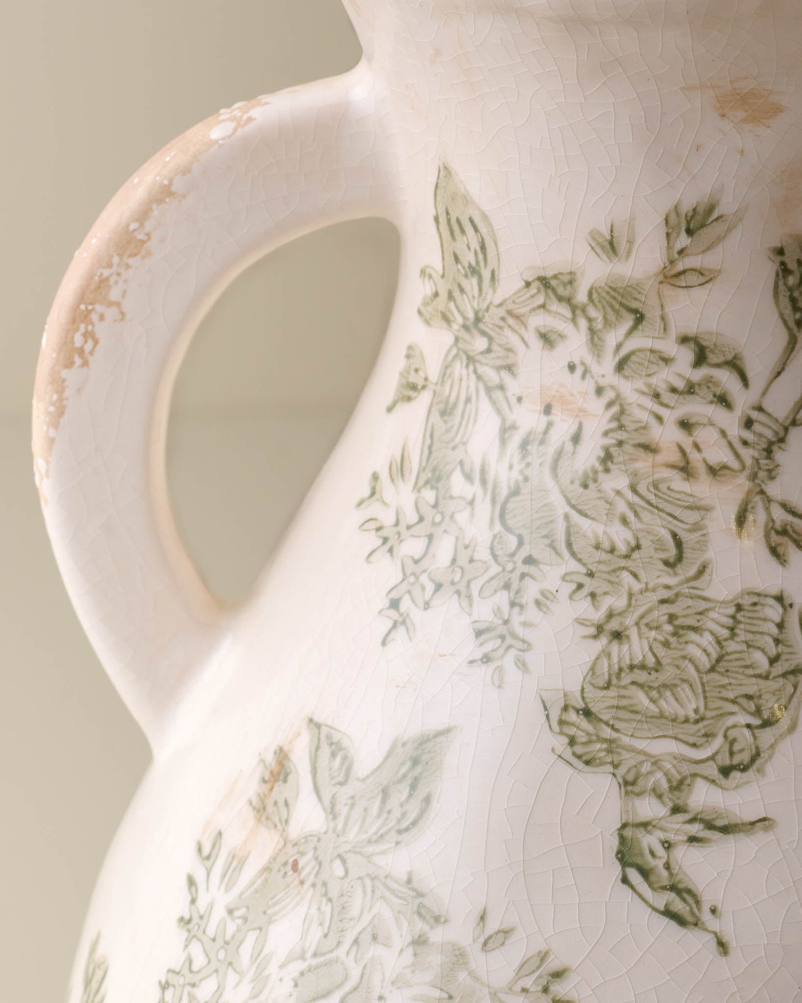 Close up of distressed vase Green and White floral detail