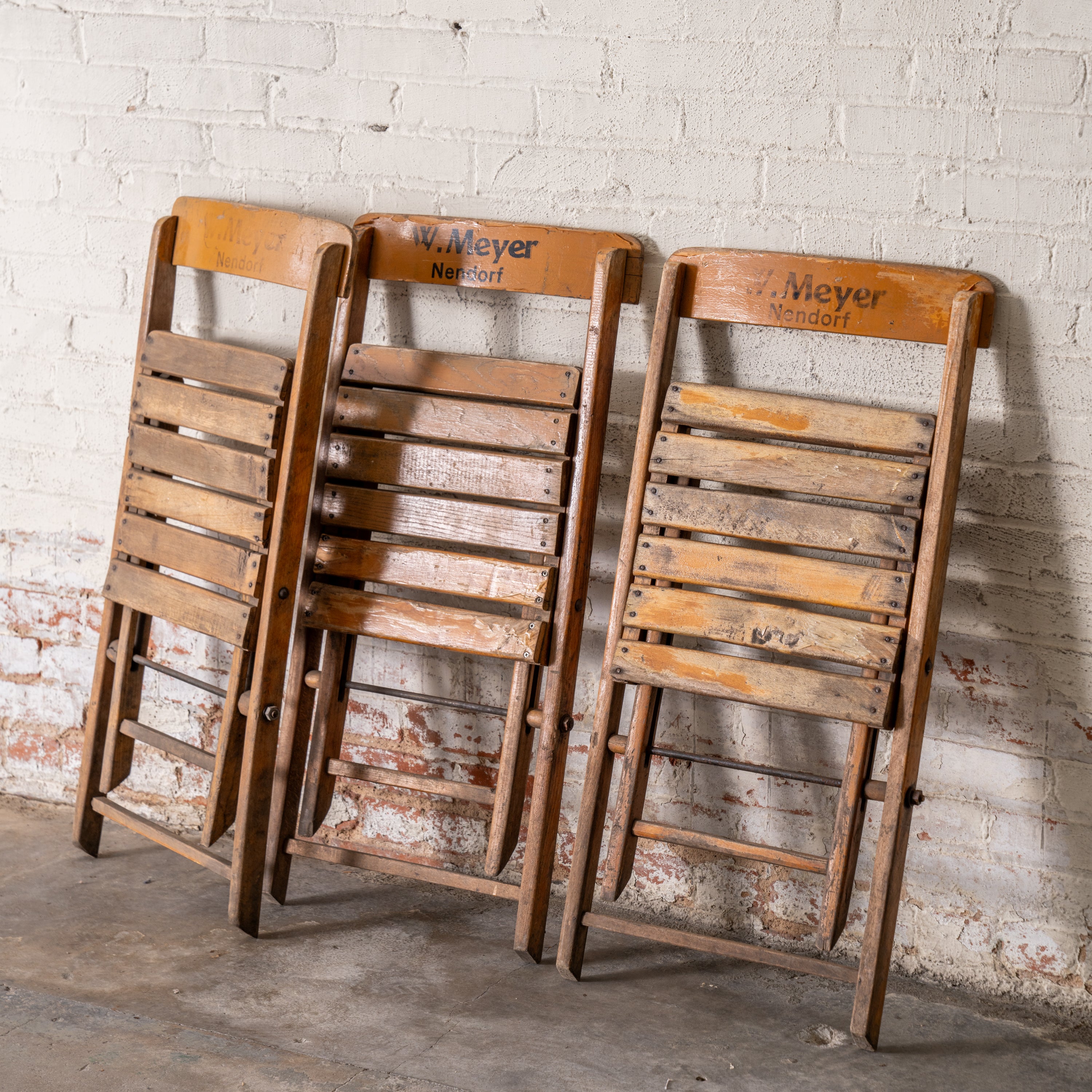 Vintage Wooden German Folding Chairs shown leaning up against wall