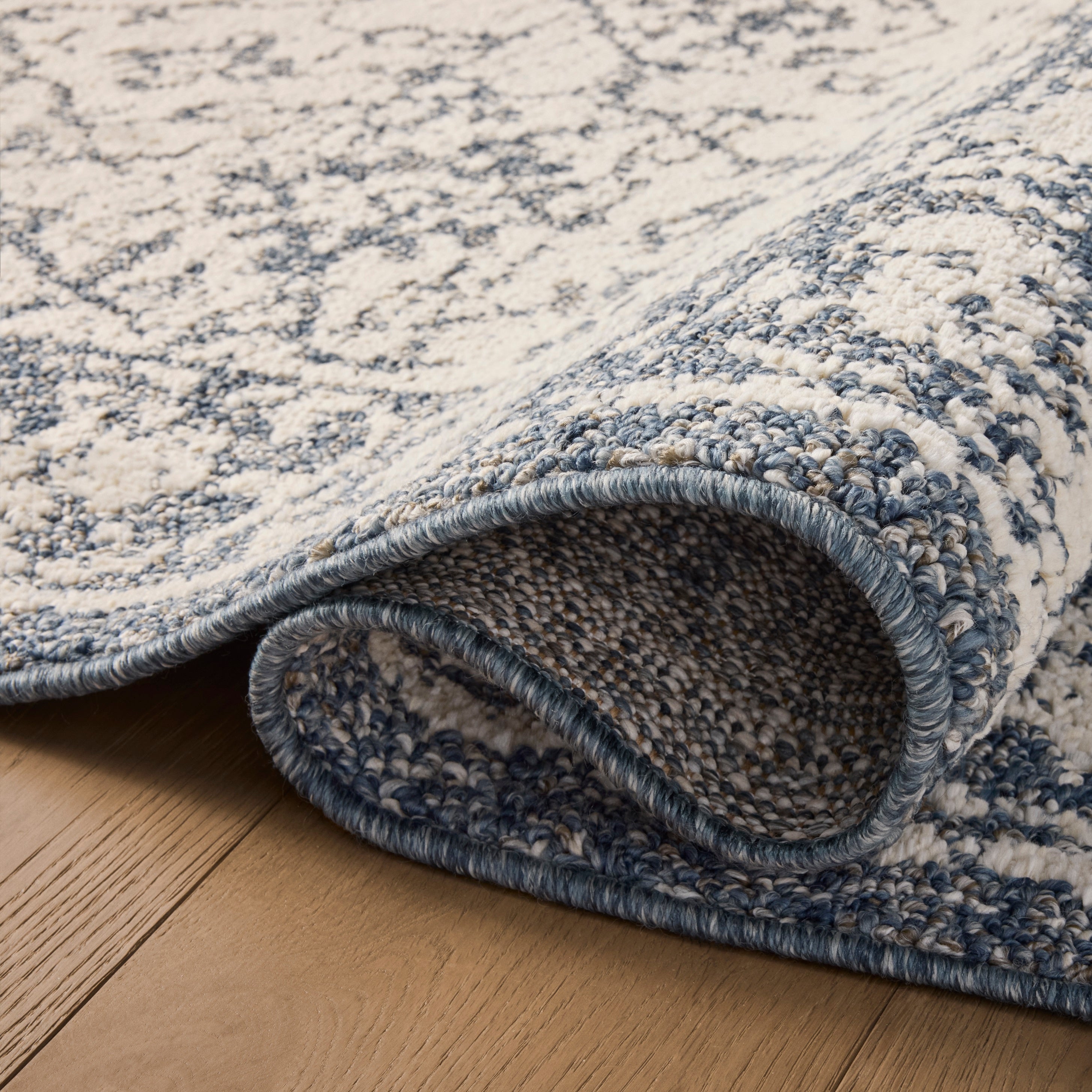 Gigi Ivory Blue Rug close up of rolled rug