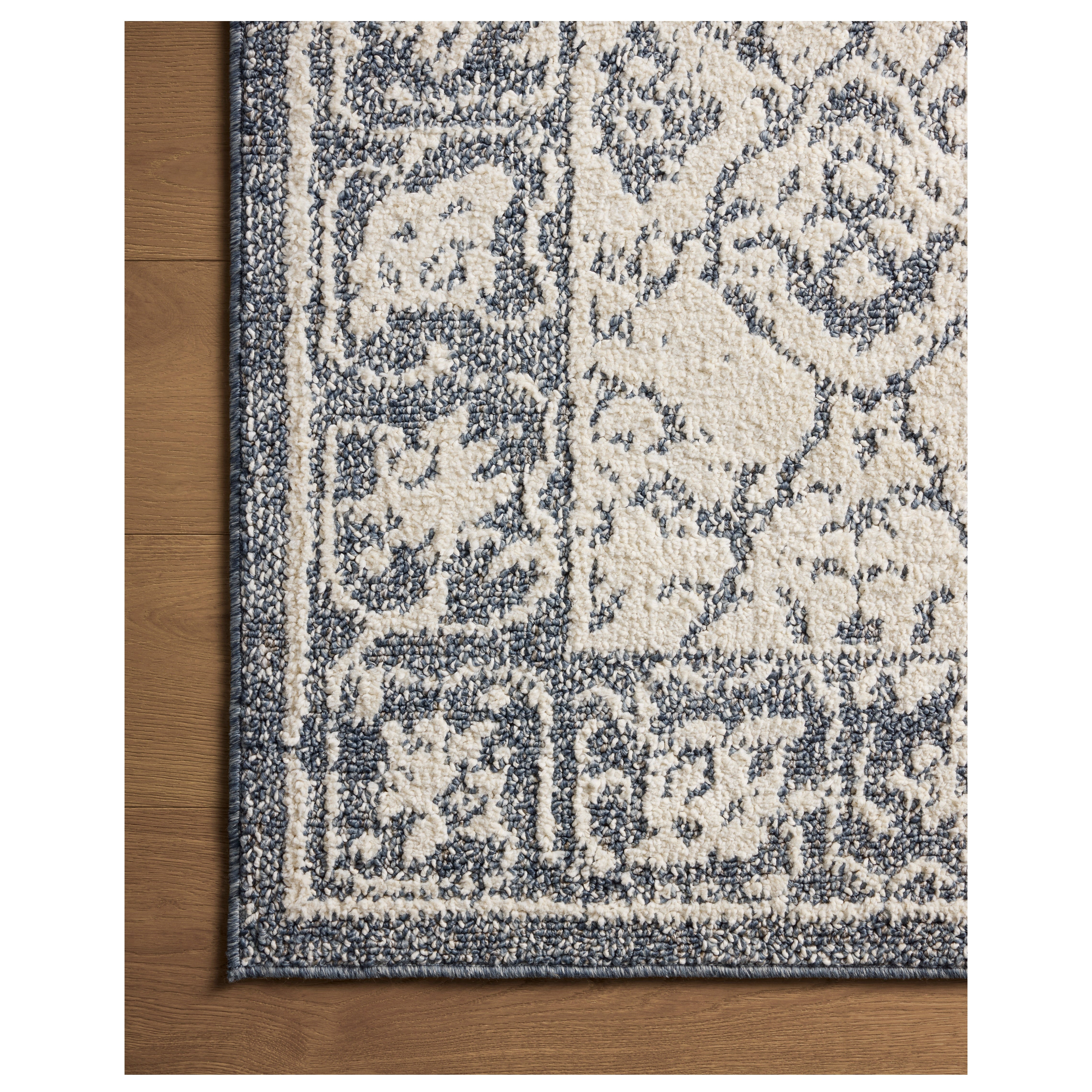Gigi Ivory Blue Rug close up of corner on wood floor