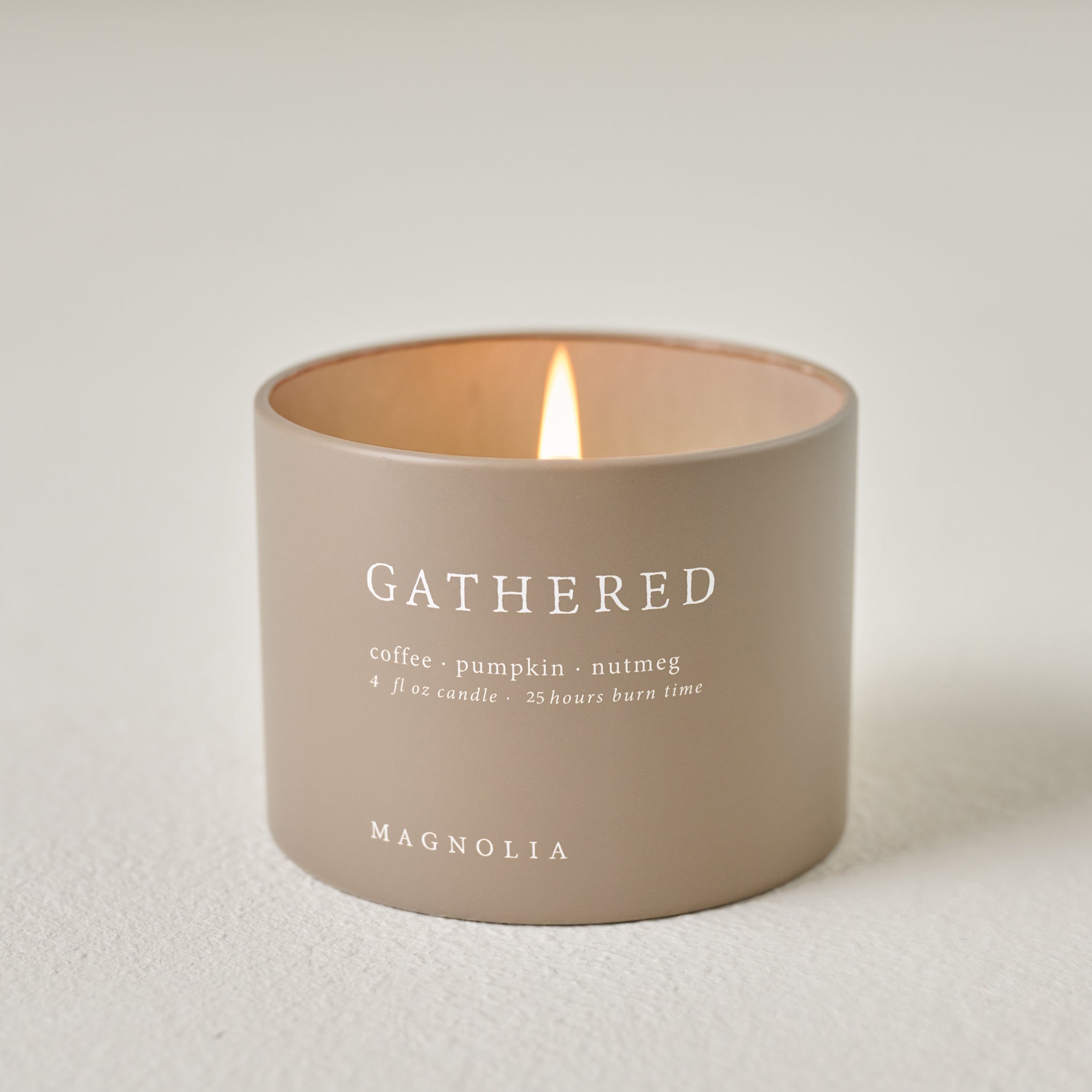 Magnoliass Gathered Candle Tin shown burning