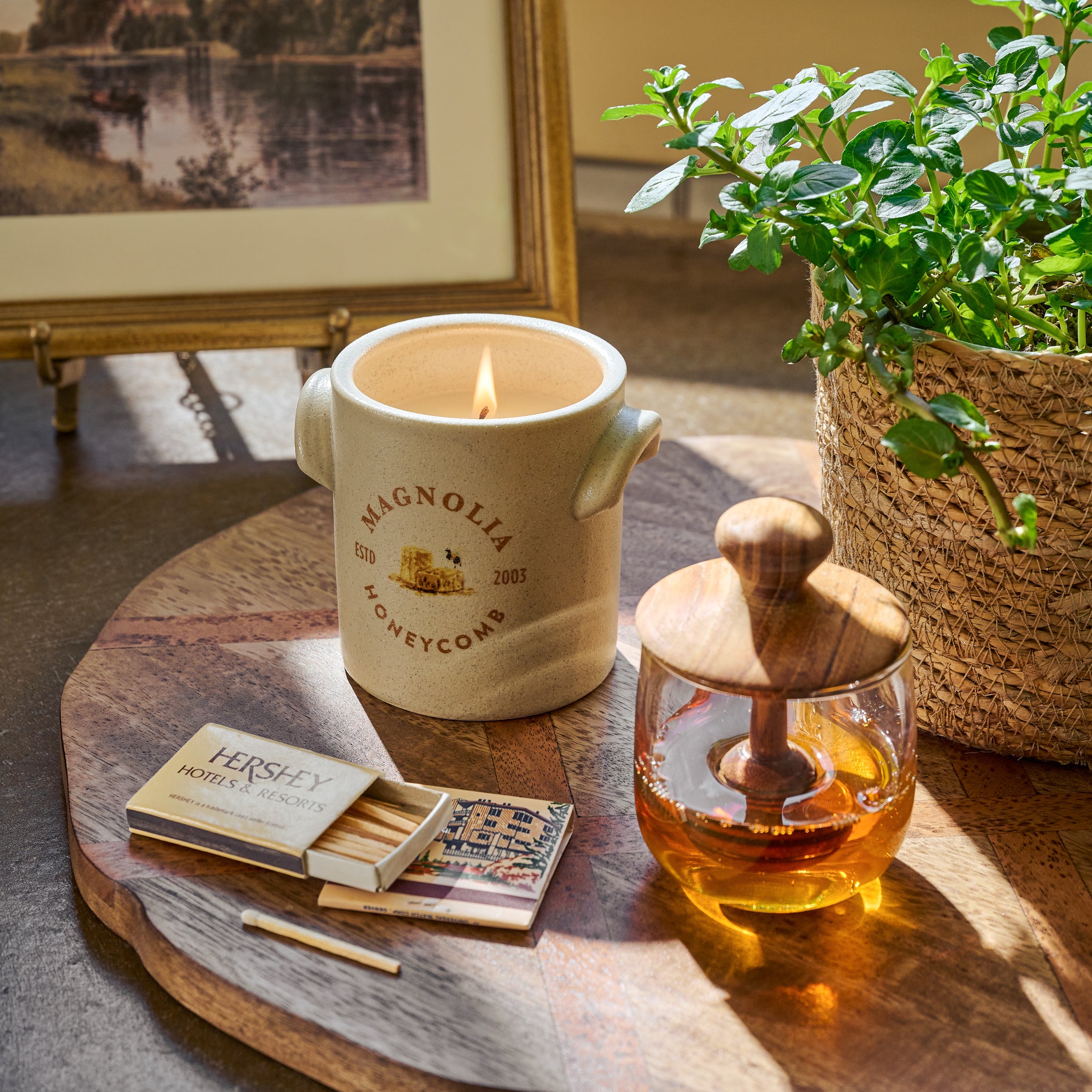 Magnoliass Honeycomb Candle next to matches and a honey pot