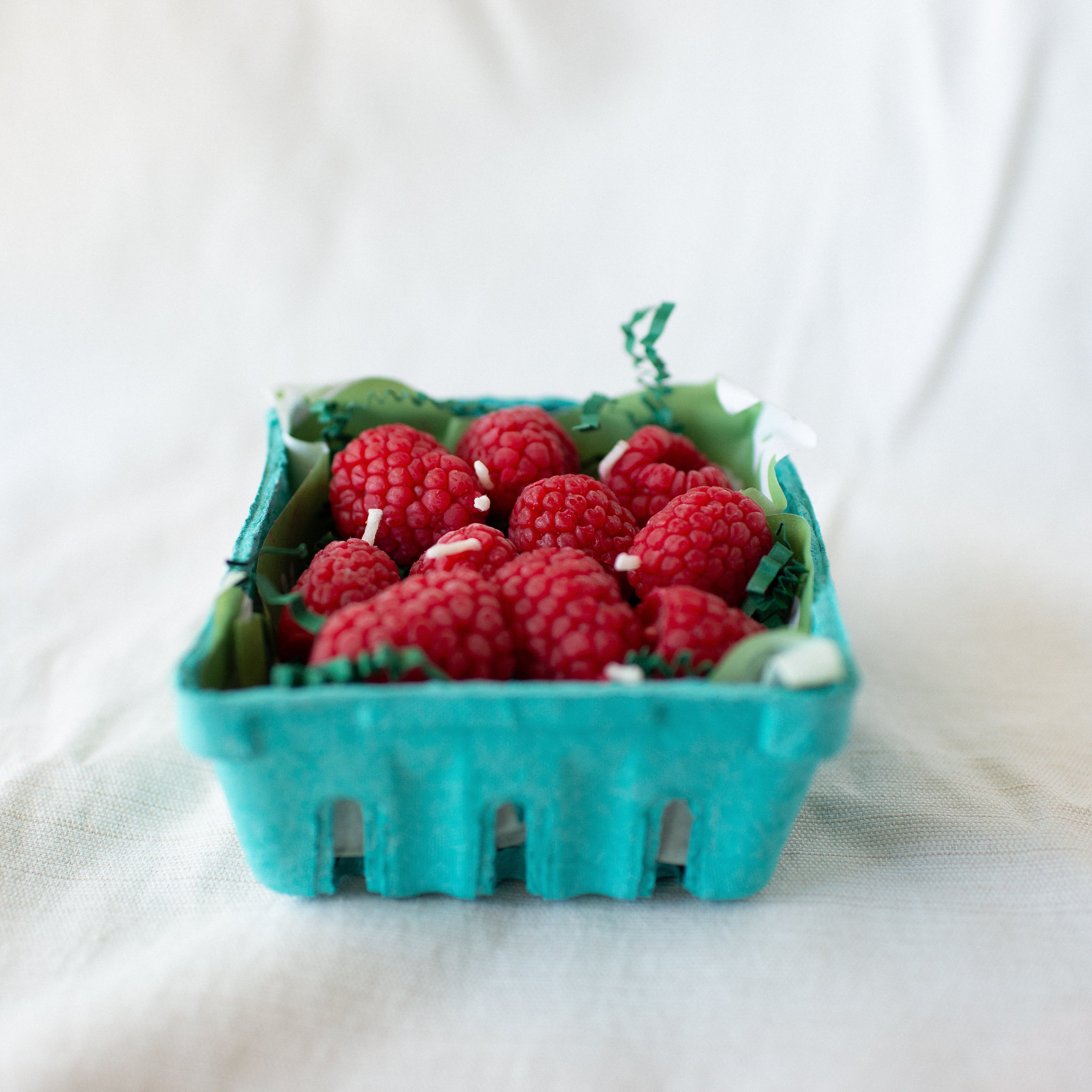 Raspberry Birthday Candle Set of 10 shown up cose in carton