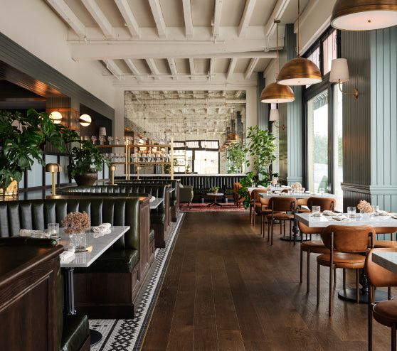 The Brasserie at Hotel 1928, a modern restaurant interior with wooden floors, tables, chairs, and decorative elements.
