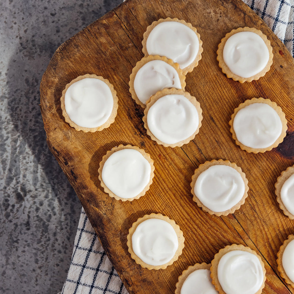 Crew's Cookies with white icing on a wooden board.