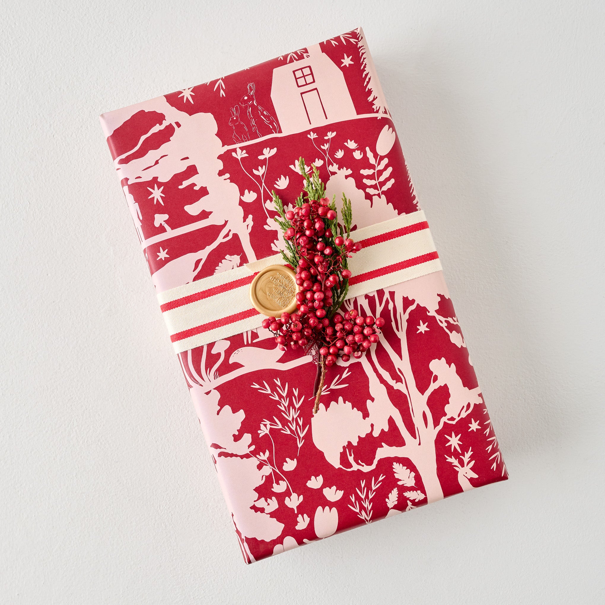 Magnoliass Burgundy Woodland Wrapping Paper Sheets shown on gift