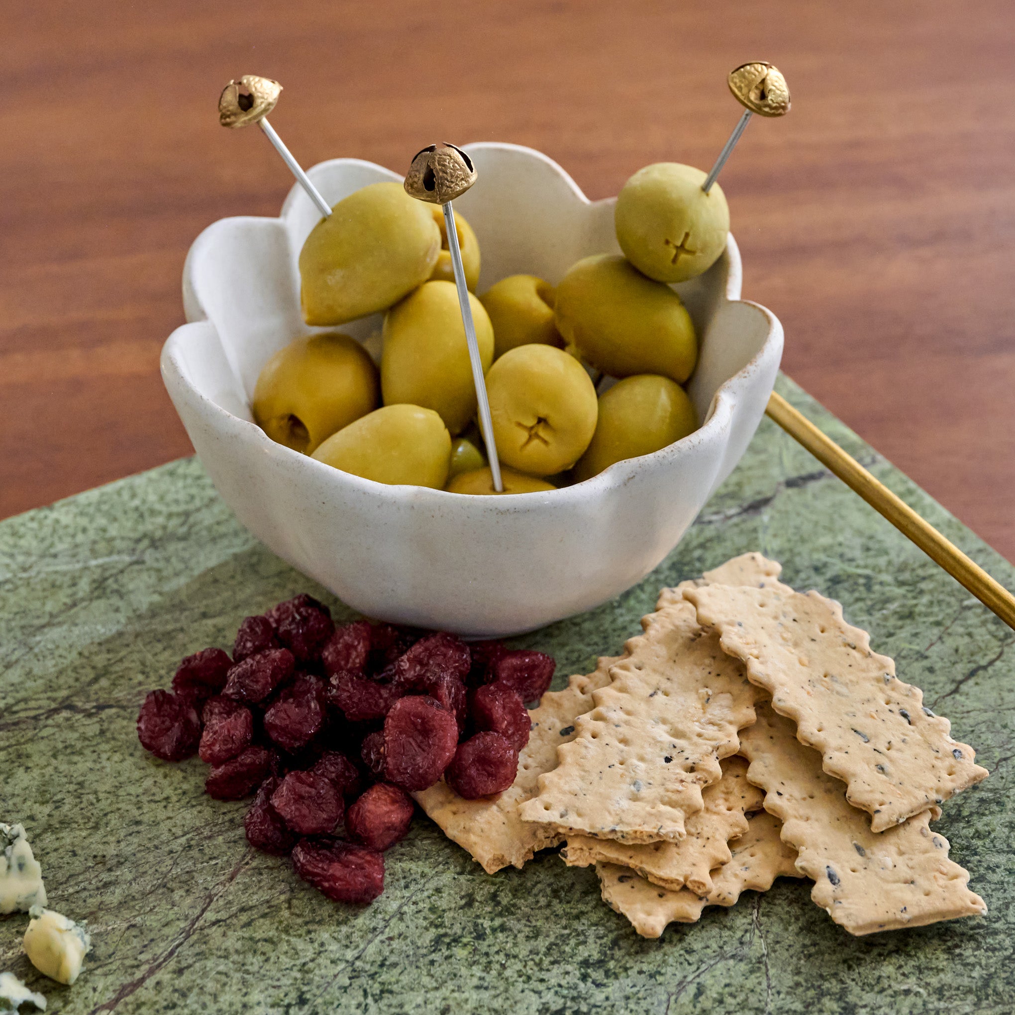 Brass Jingle Bell Cocktail Picks shown in bowl of oilves
