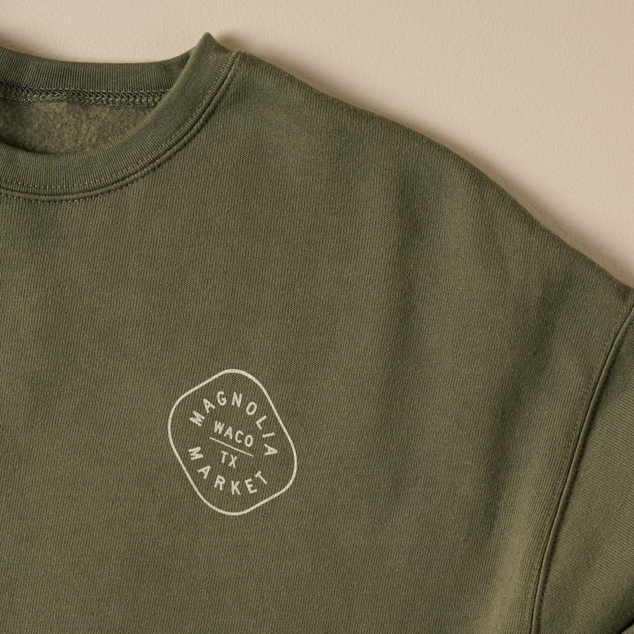 Katy Ballpark Military Green Crewneck front close up of Magnoliass logo on chest