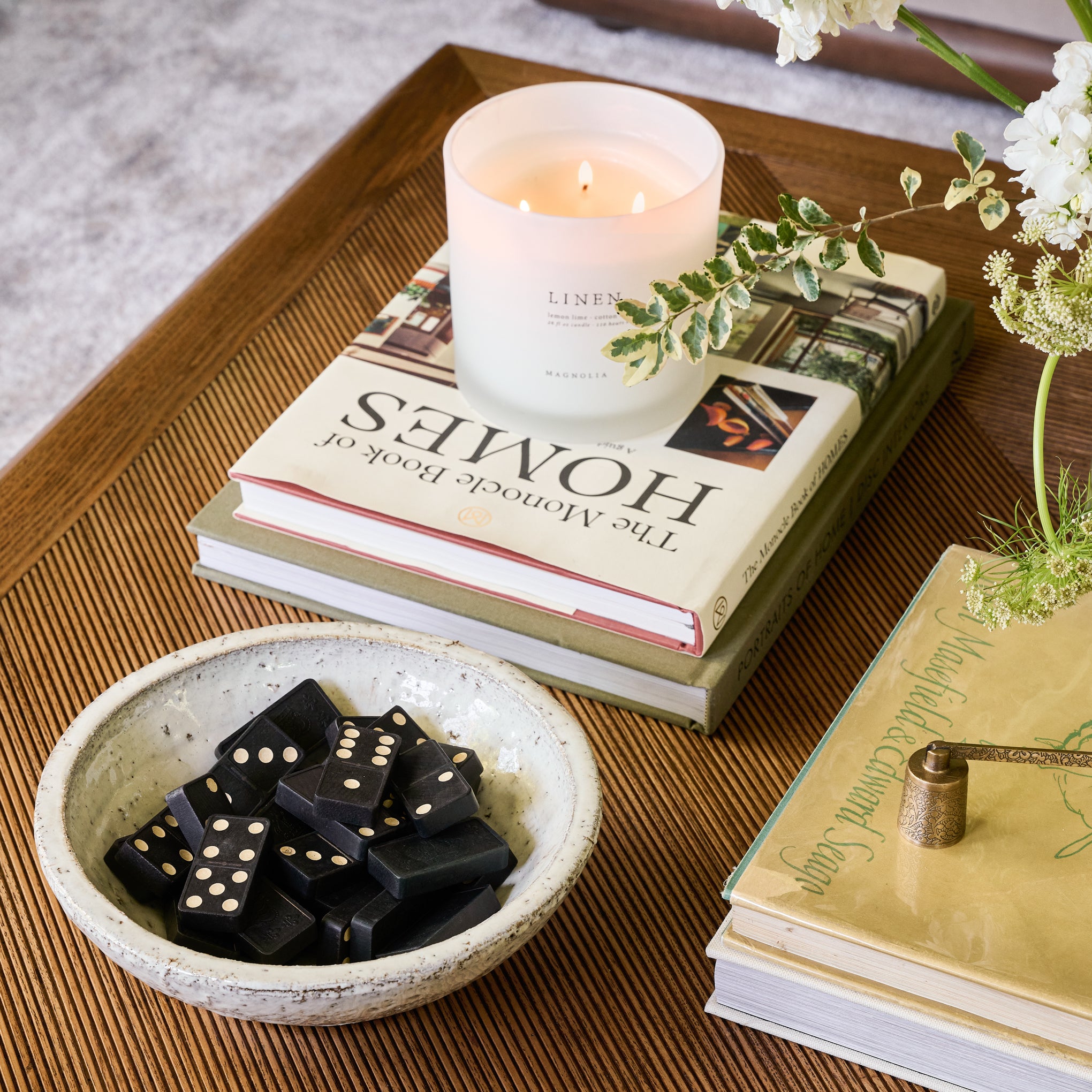 Magnoliass Linen Candle on a coffee table book on a coffee table