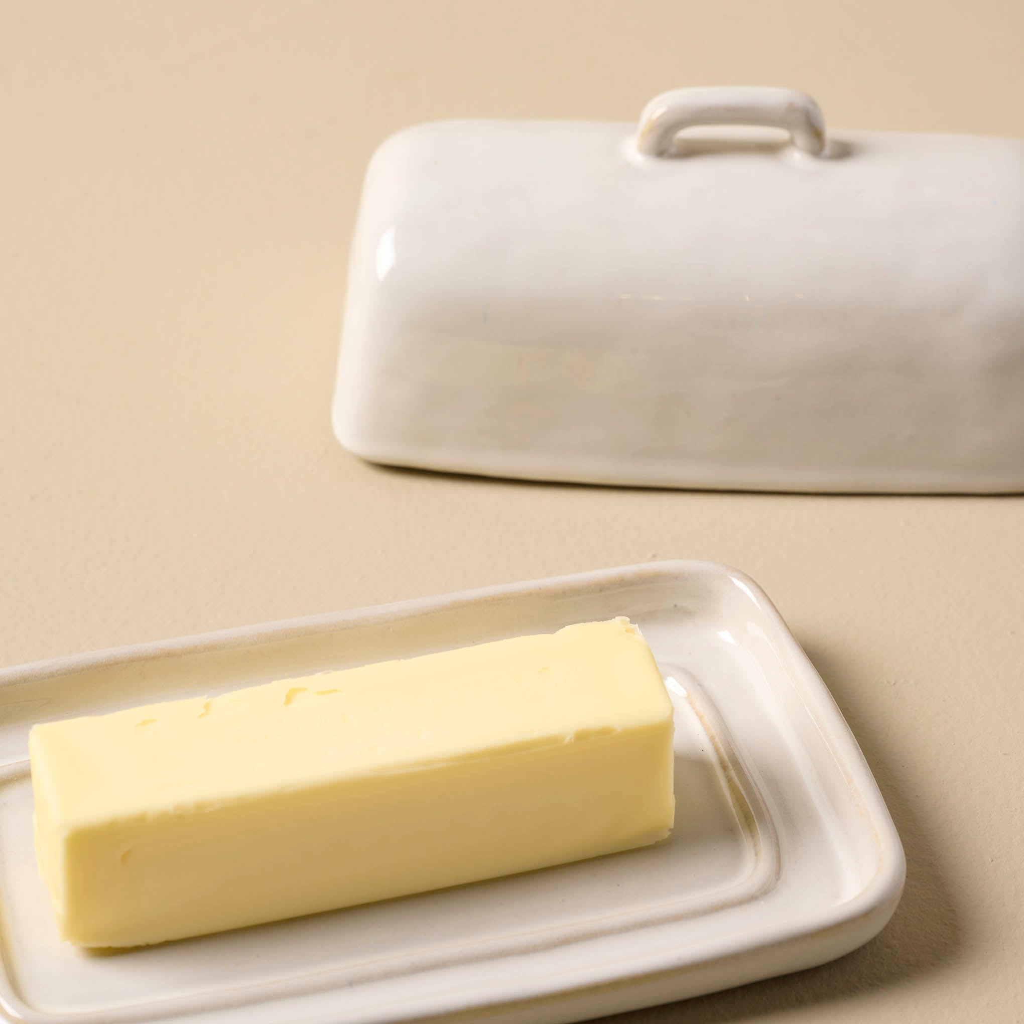 Magnoliass Est. Ceramic Butter Dish with butter in it and lid off to the side