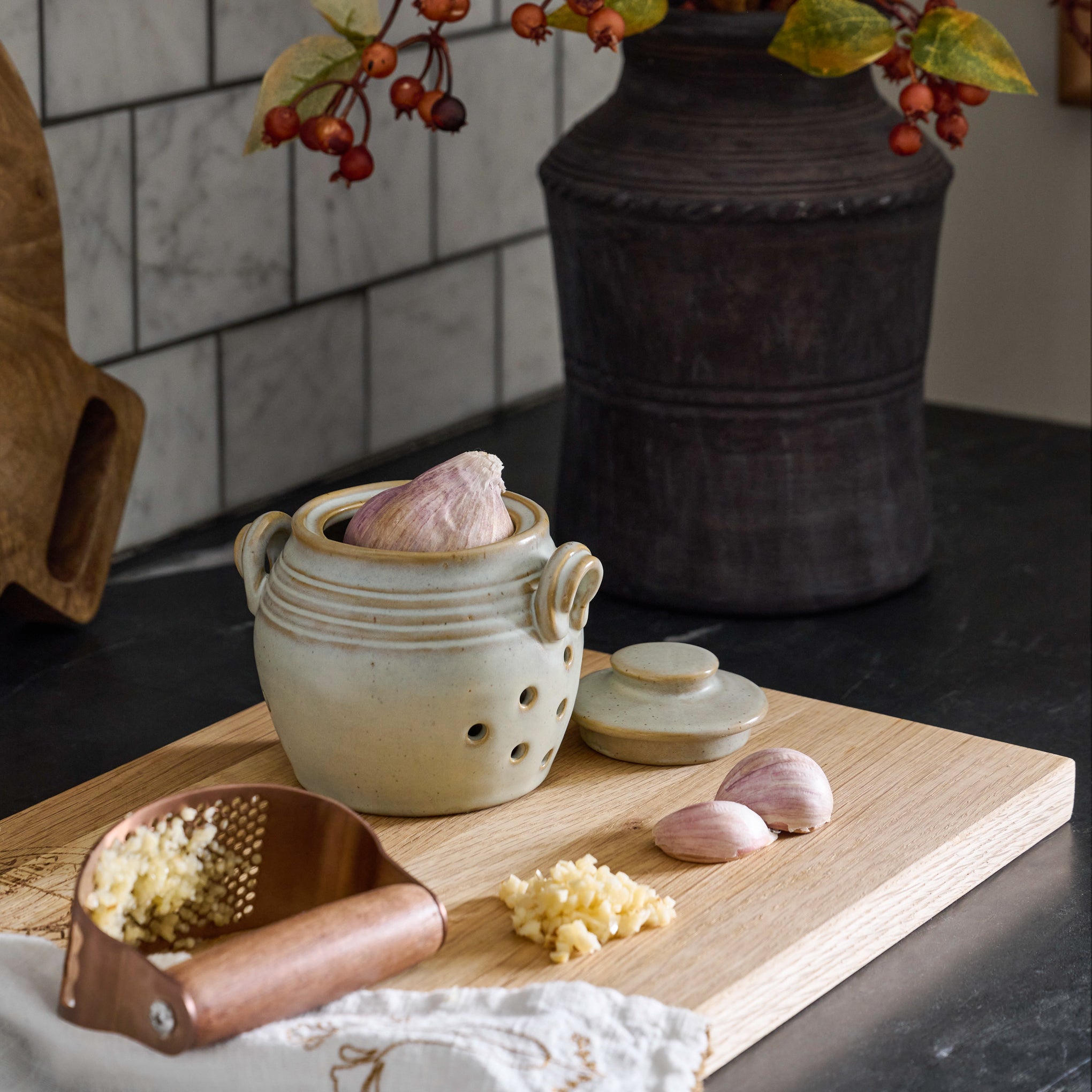 Copper and Walnut Garlic Rocker shown with garlic keeper on serving board