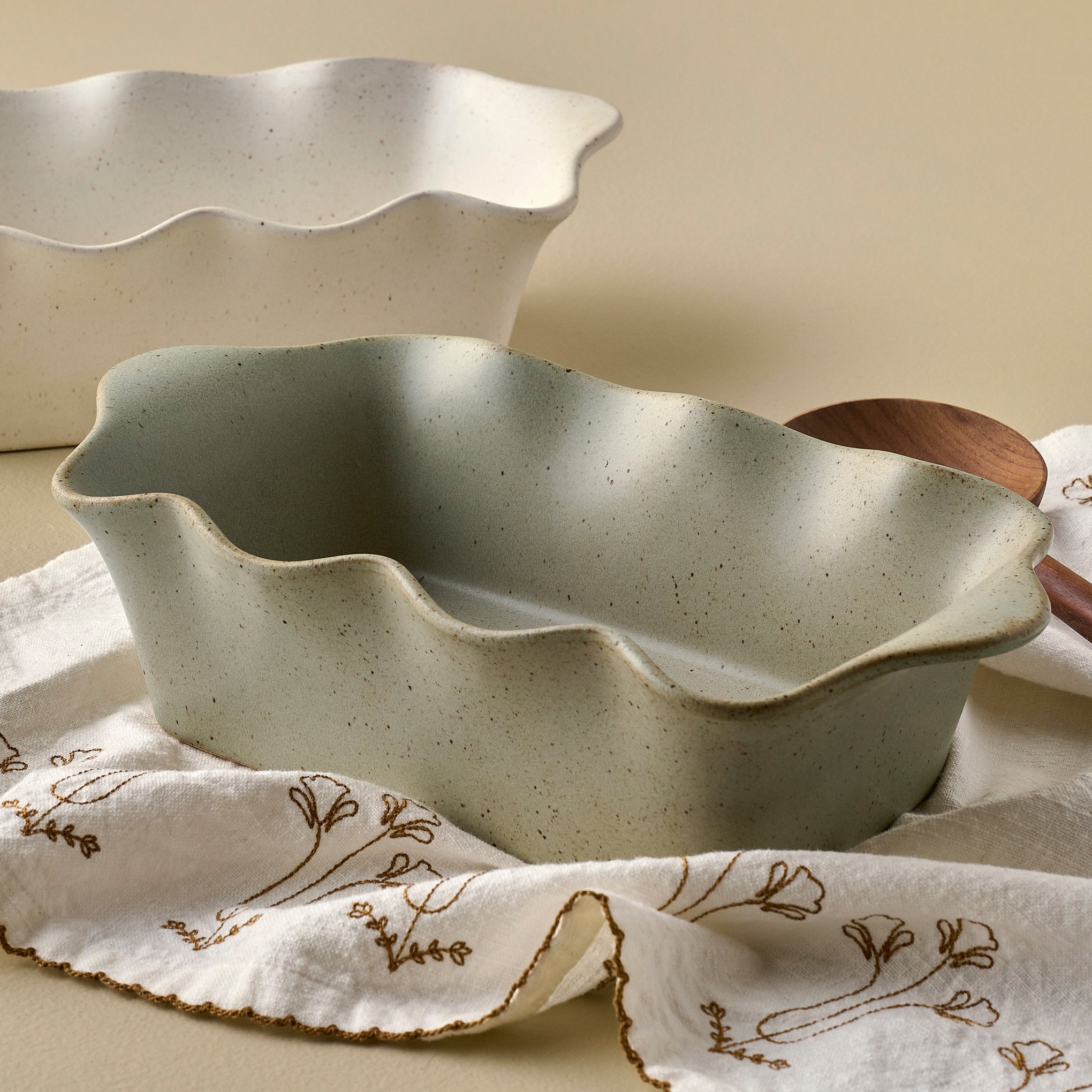 Loden Green Scalloped Loaf Pan shown with tea towel and serveware