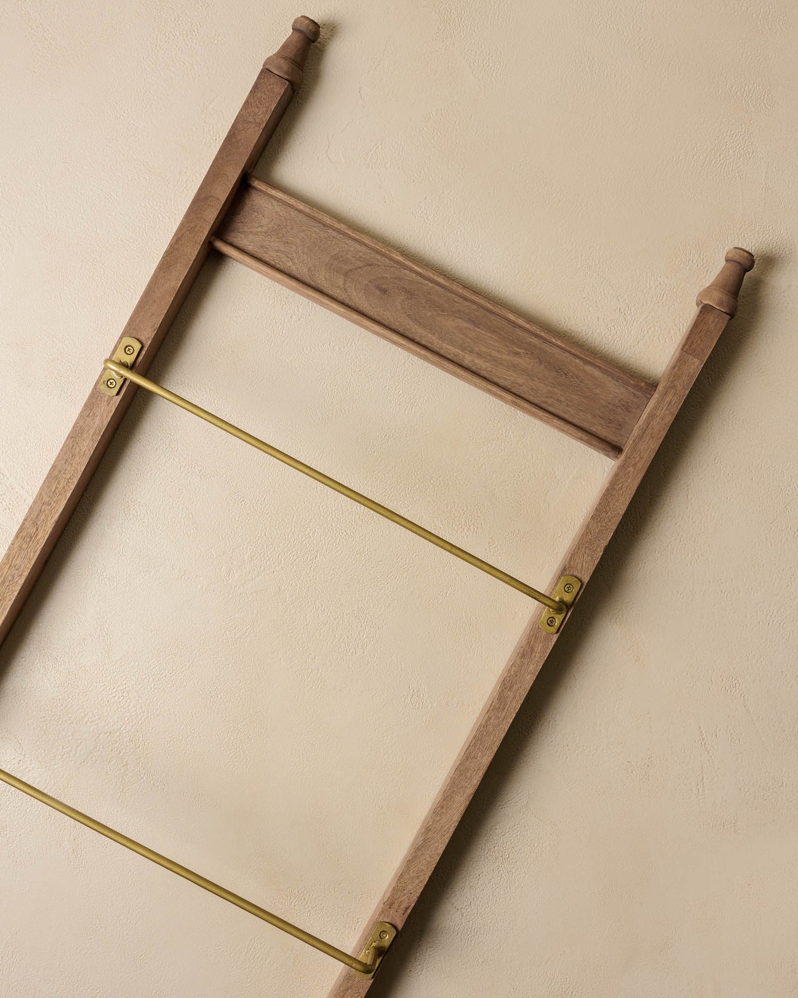 Brass and Wood Library Ladder against a beige surface
