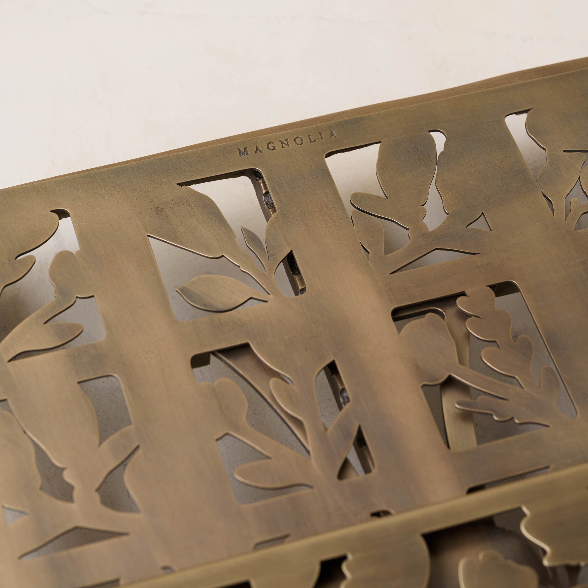 Antique Brass Shadow Floral Cookbook Stand close up showing Magnoliass logo embossing