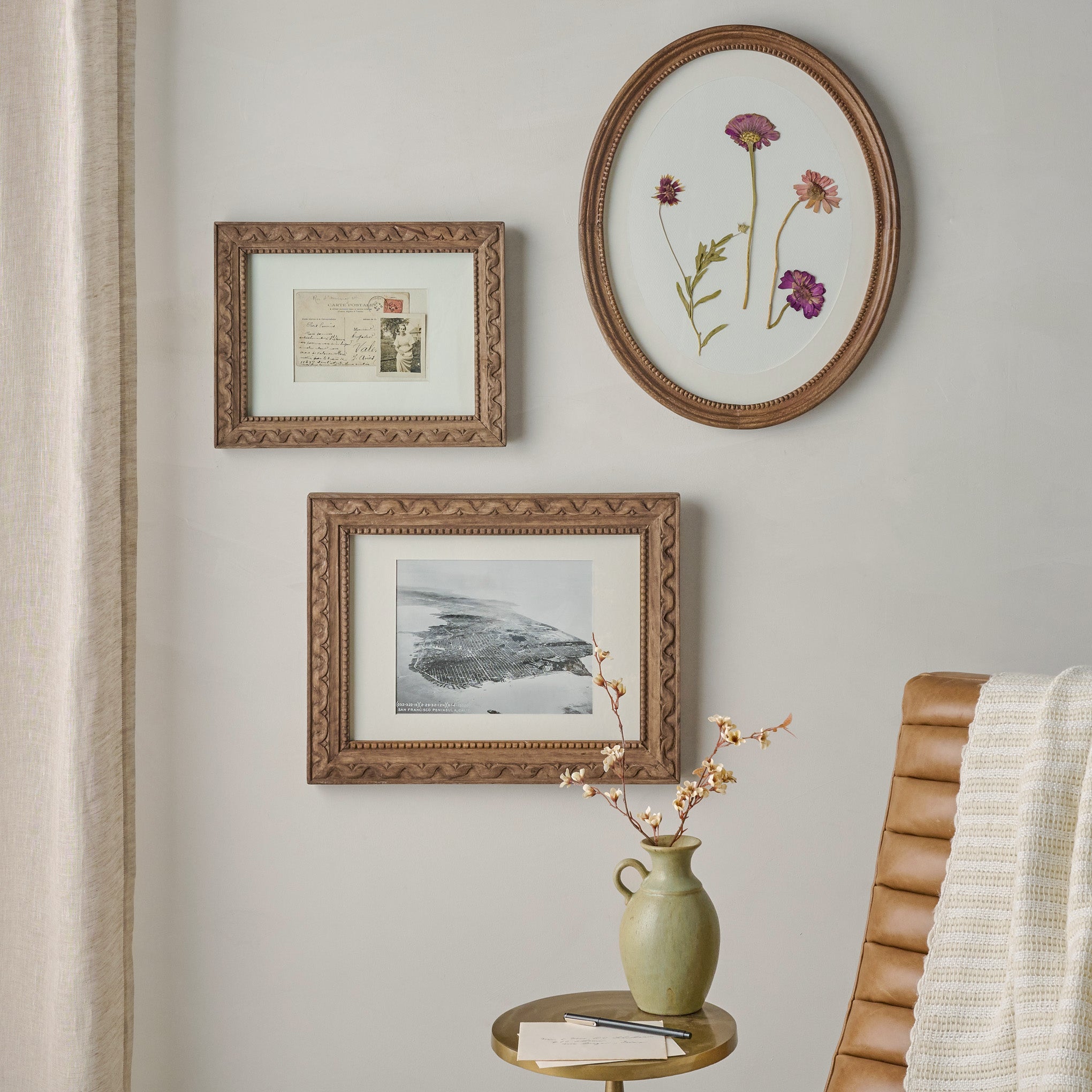 Willa Antiqued Wood Oval Picture Frame shown on wall 