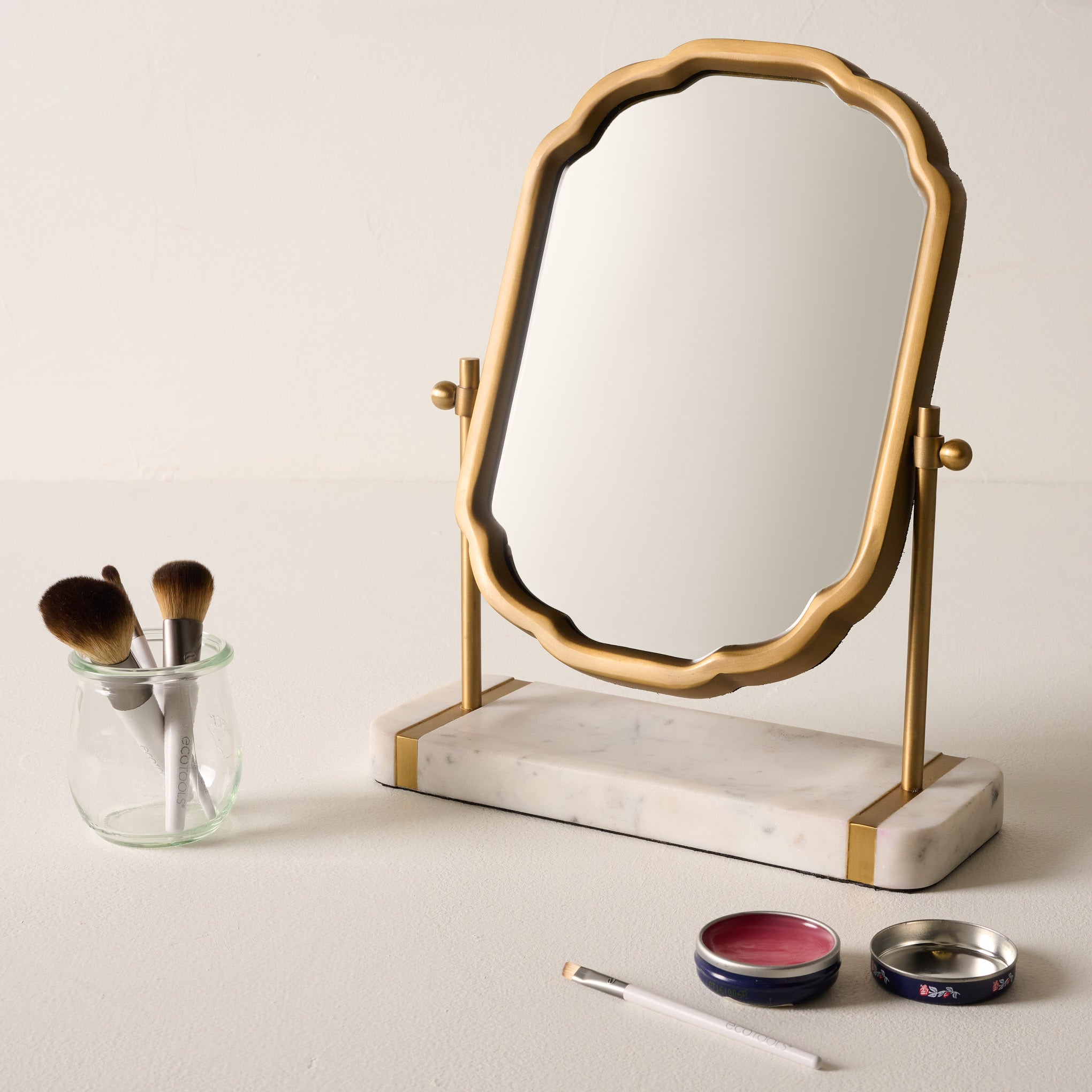 Antique Brass and Marble Vanity Mirror shown with makeup products