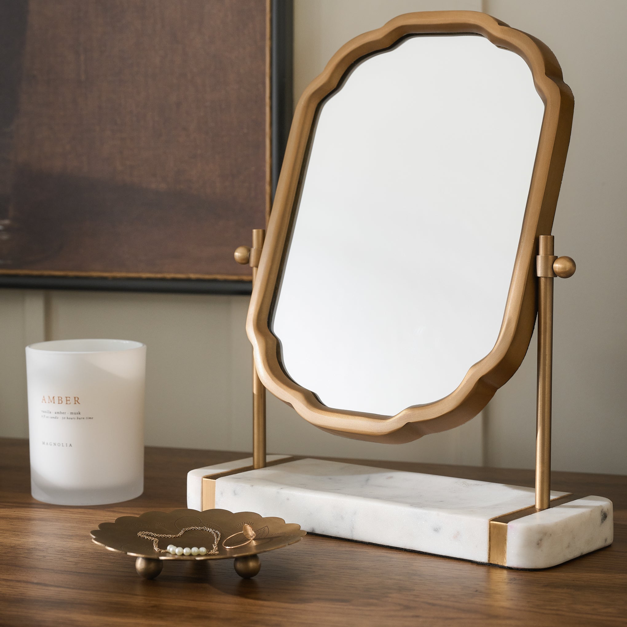 Antique Brass and Marble Vanity Mirror shown with candle and trinket tray on wood table