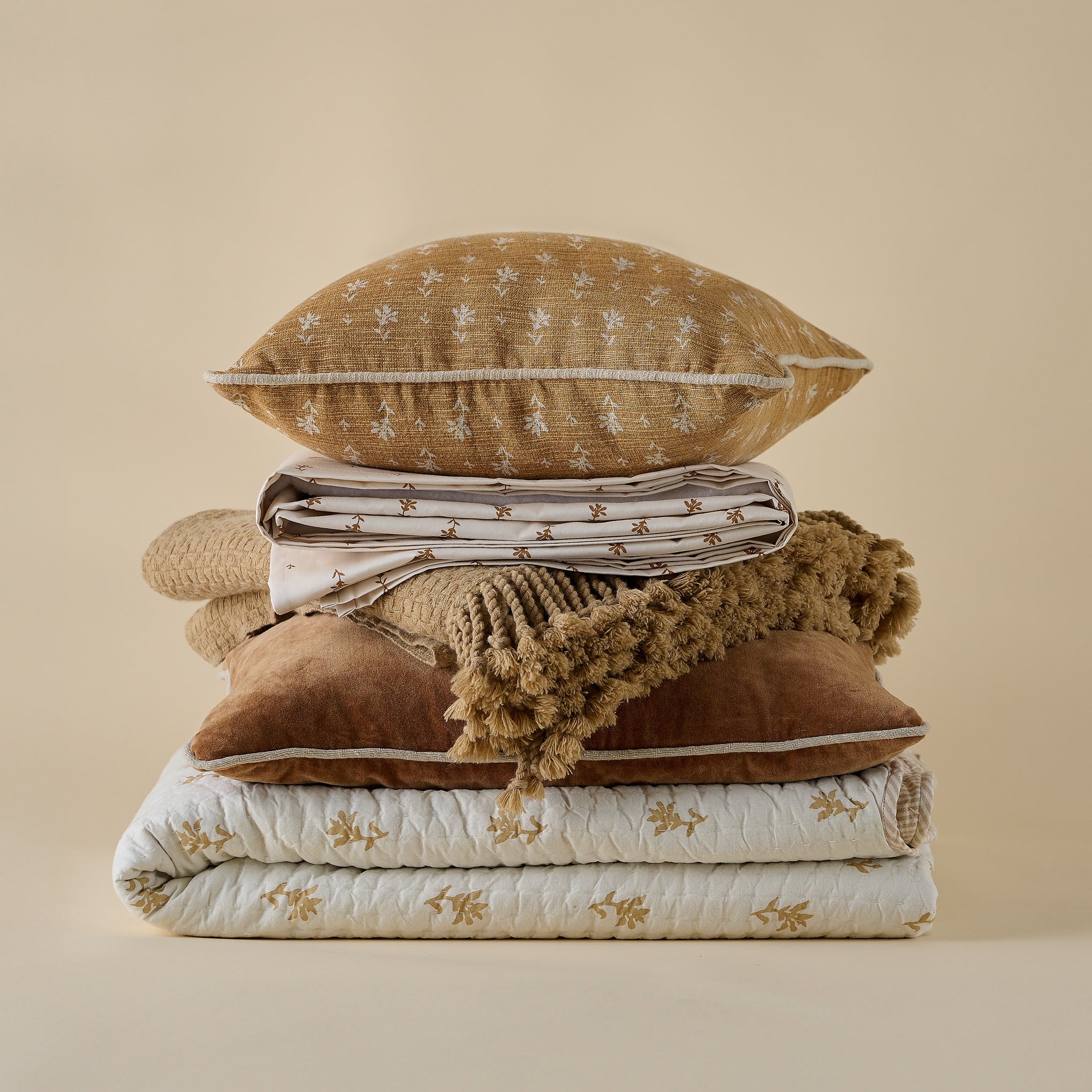 Ochre Basketweave Throw shown in stack of fall bedding