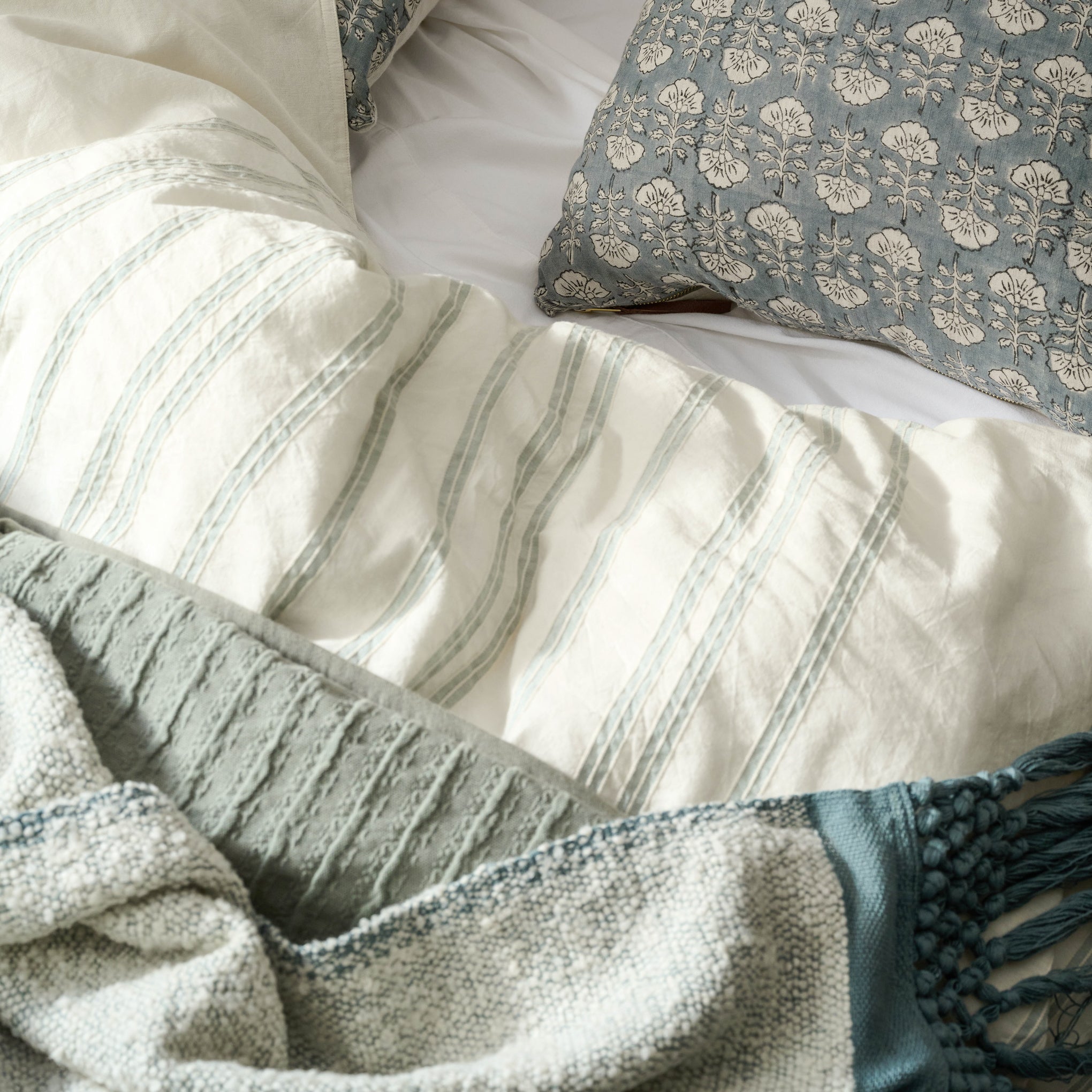 Embroidered Stripe Linen Cotton Duvet Cover - Chambray on a bed