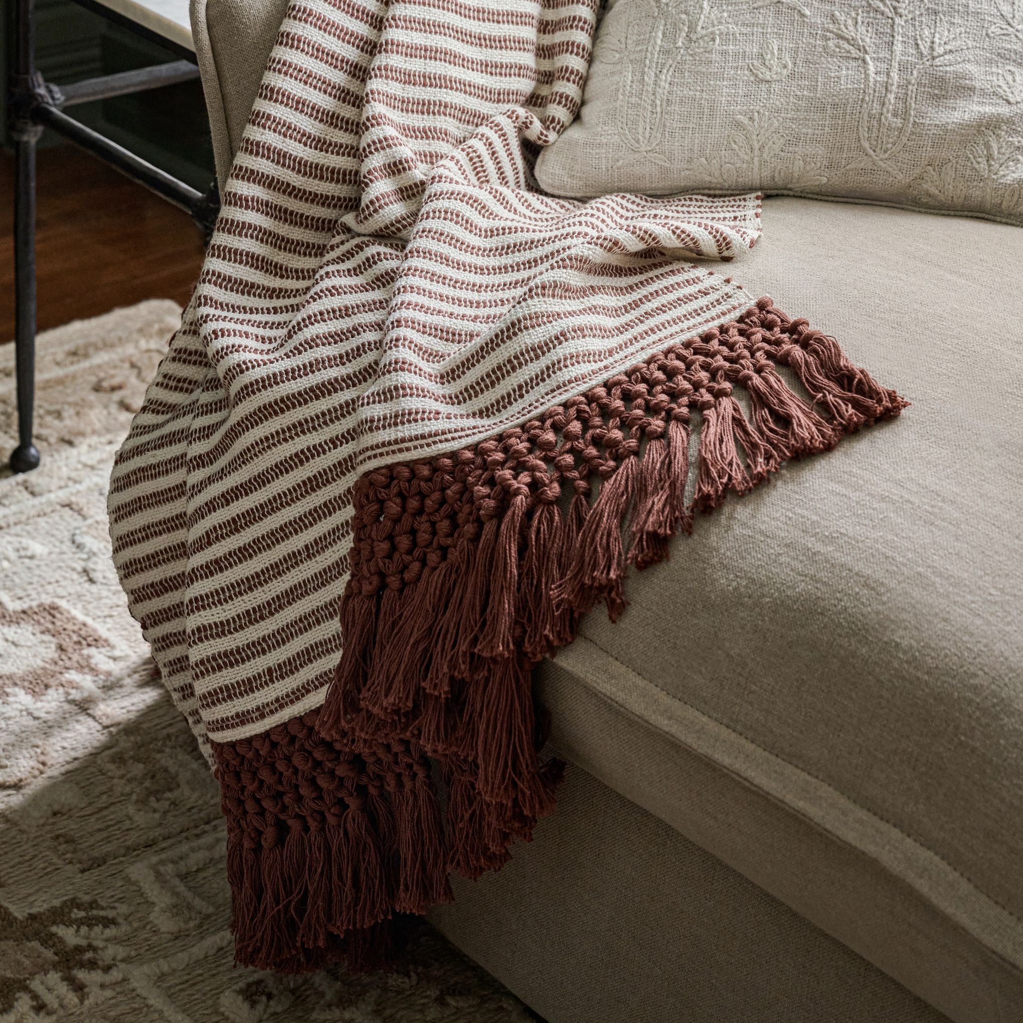 Essential Tassel Throw - Burgundy Striped shown draped over couch