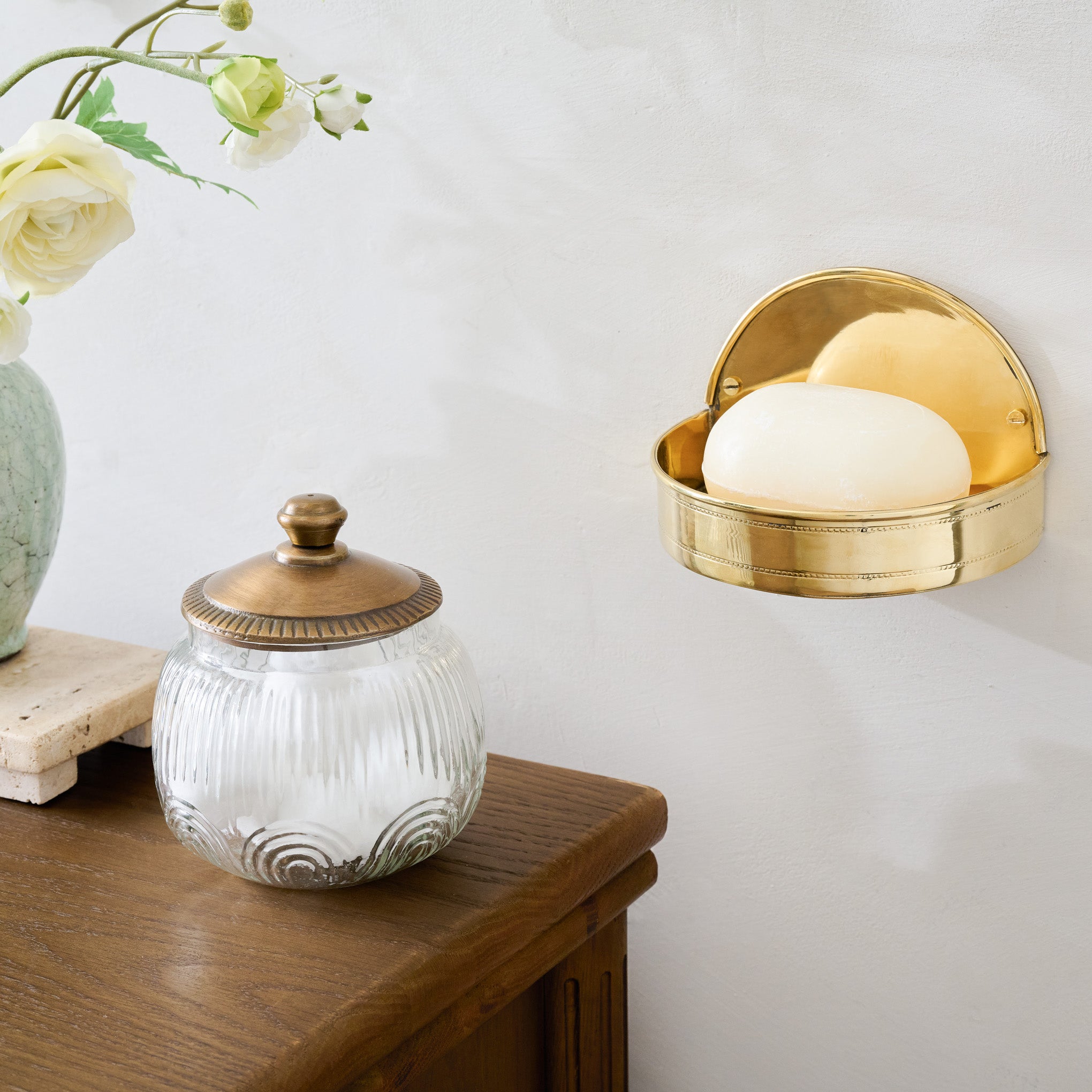 Brass Hanging Soap Dish shown on wall  by vanity