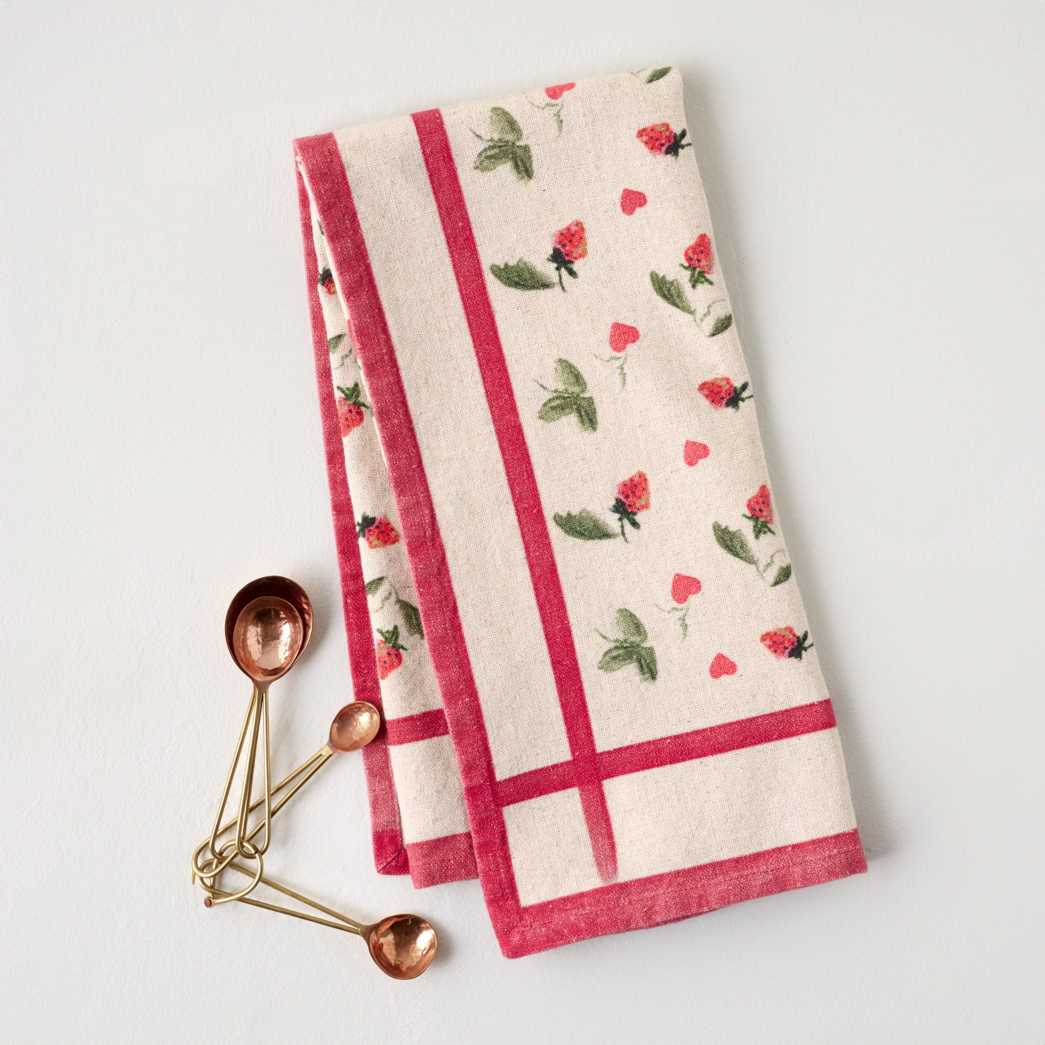 Magnoliass Strawberry + Hearts Tea Towel  shown with measuring spoons