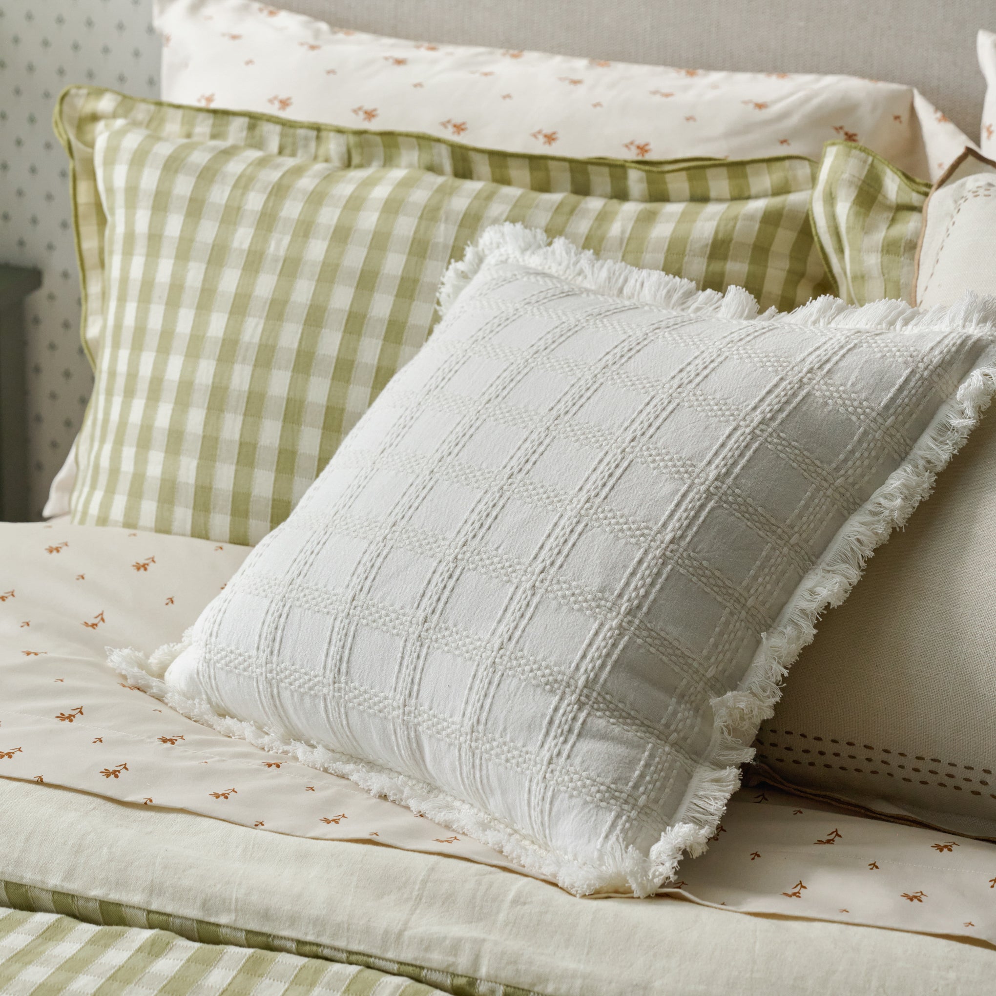 Harper Textured Grid Pillow shown on bed