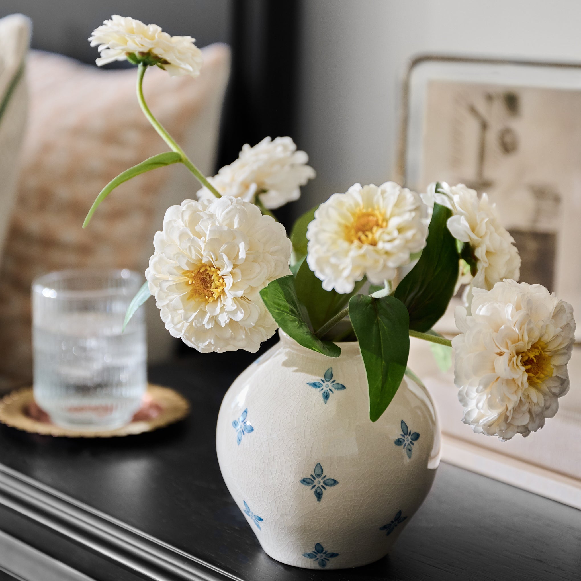 Real Touch Cream Zinnia shown in vase on nightstand